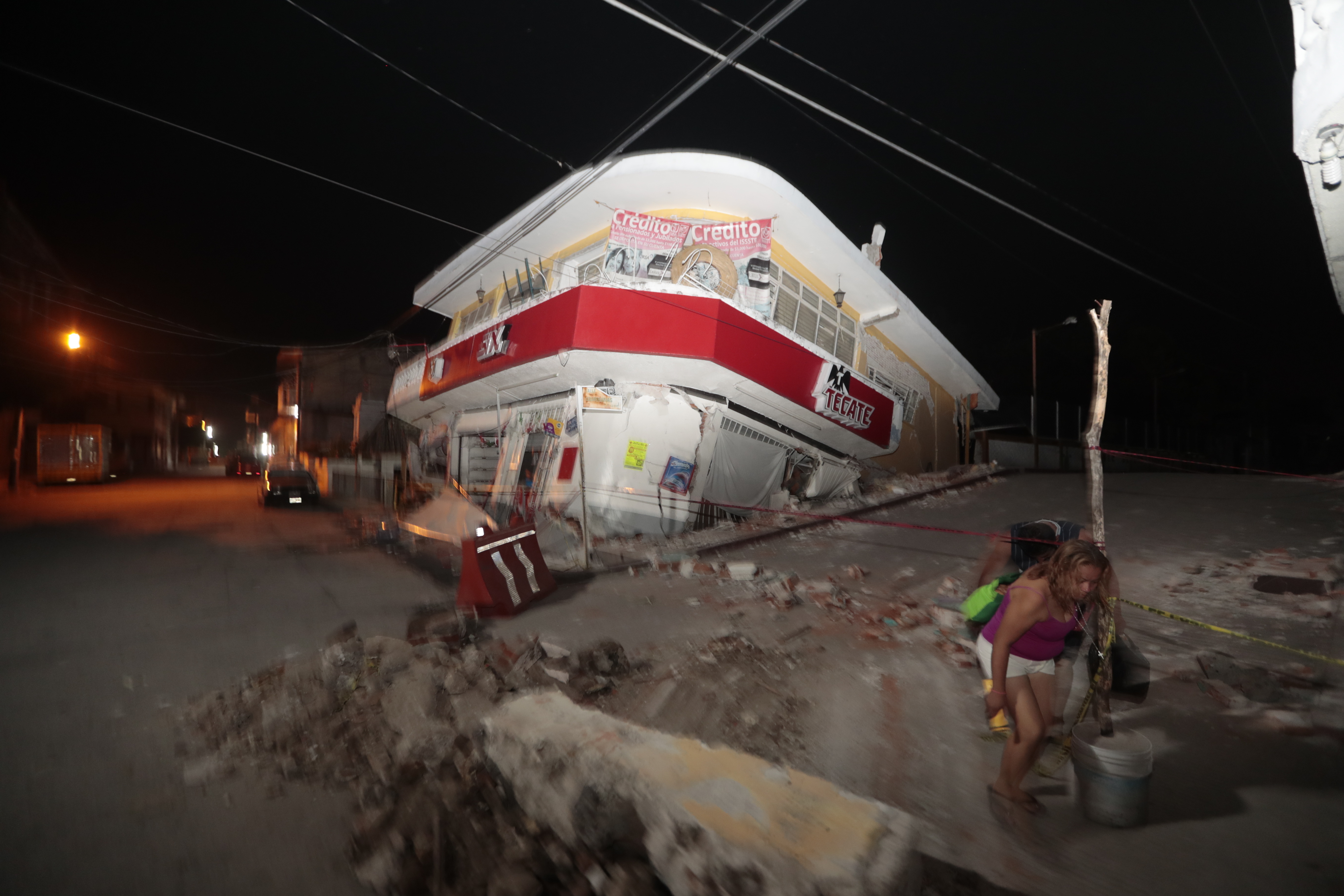 Жена покрай съборена при земетресението в Мексико сграда