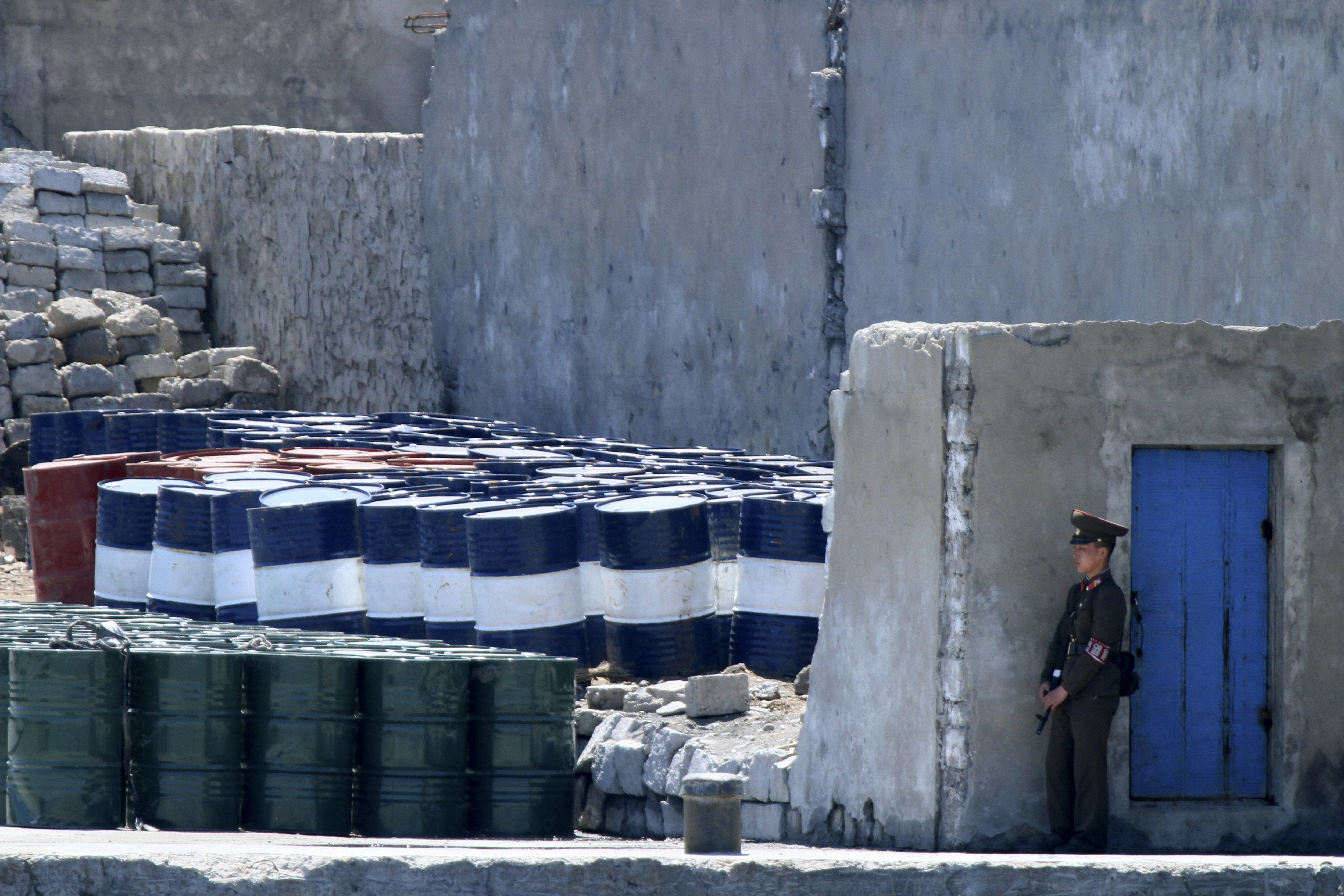 Севернокорейски войник охранява партида вносни стоки от Китай