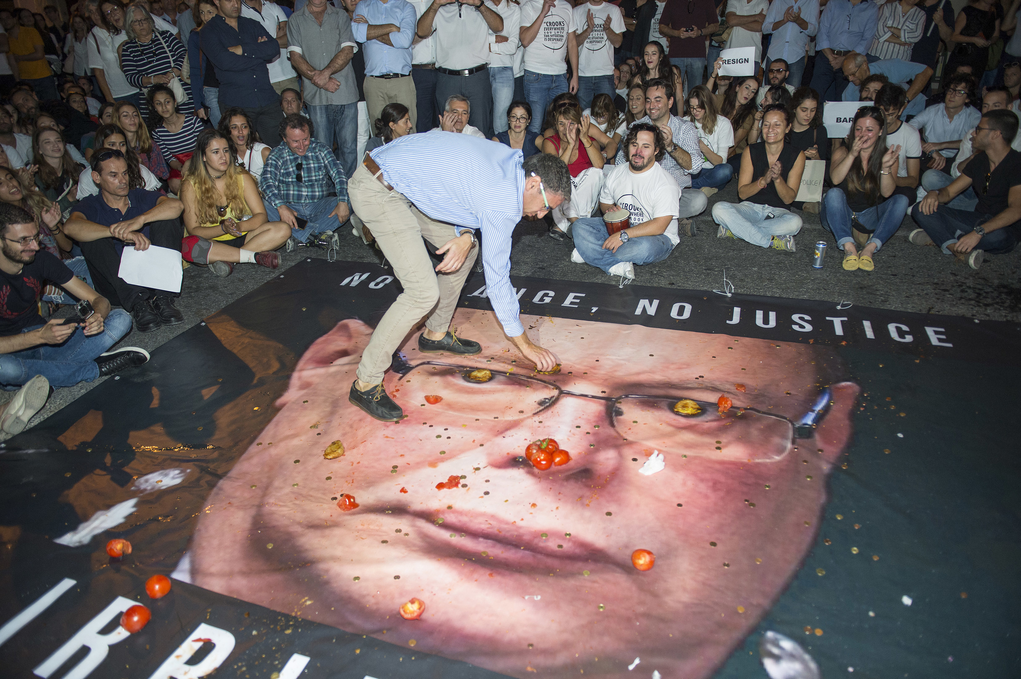 Протестиращи хвърлят домати, монети и сладкиши по плакат на началника на полицията, отговорен за разследването