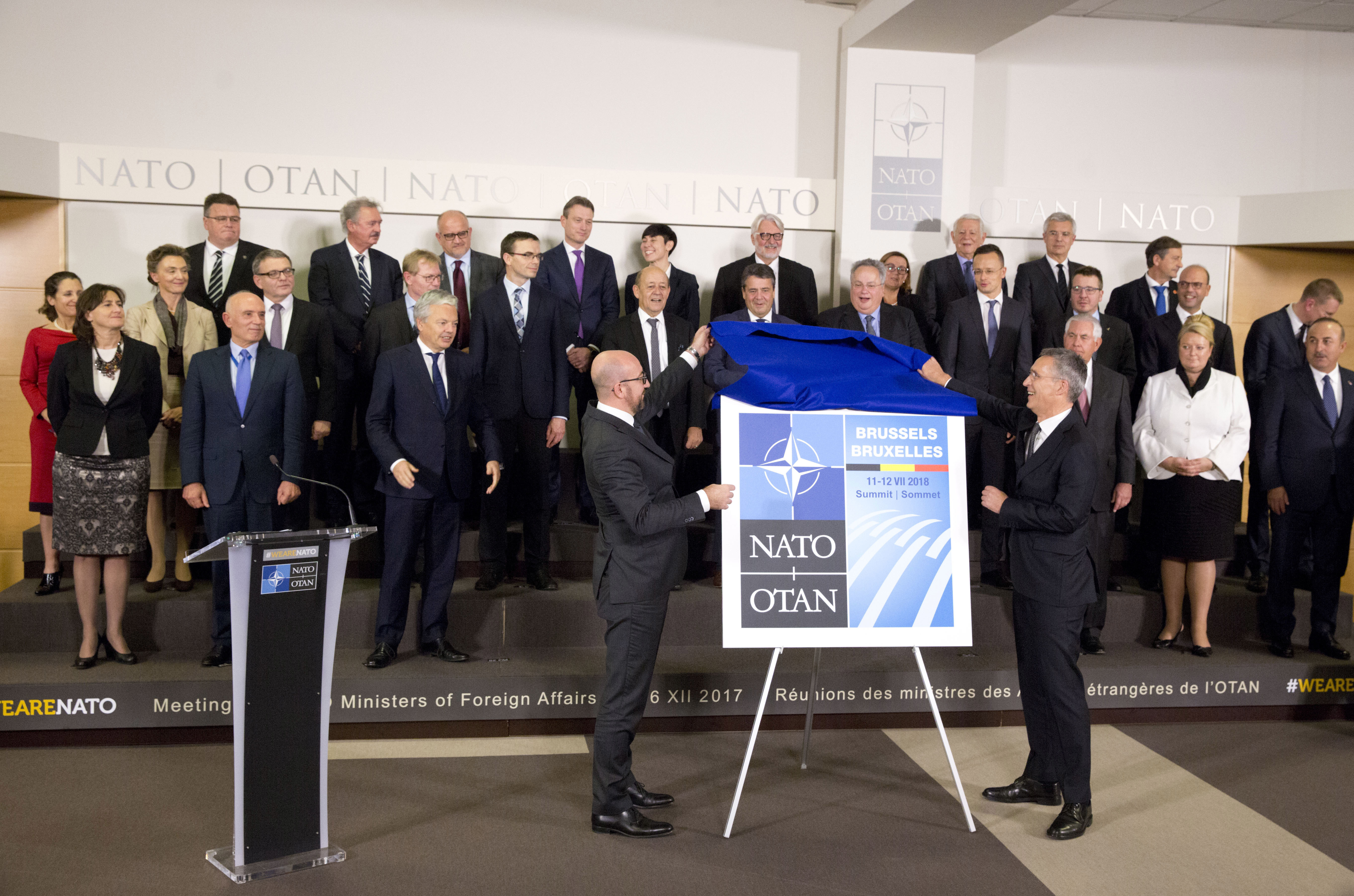 Столтенберг /вдясно/ и премиерът на Белгия Шарл Мишел показват логото на предстоящата среща на върха в НАТО през юли 2018 г.