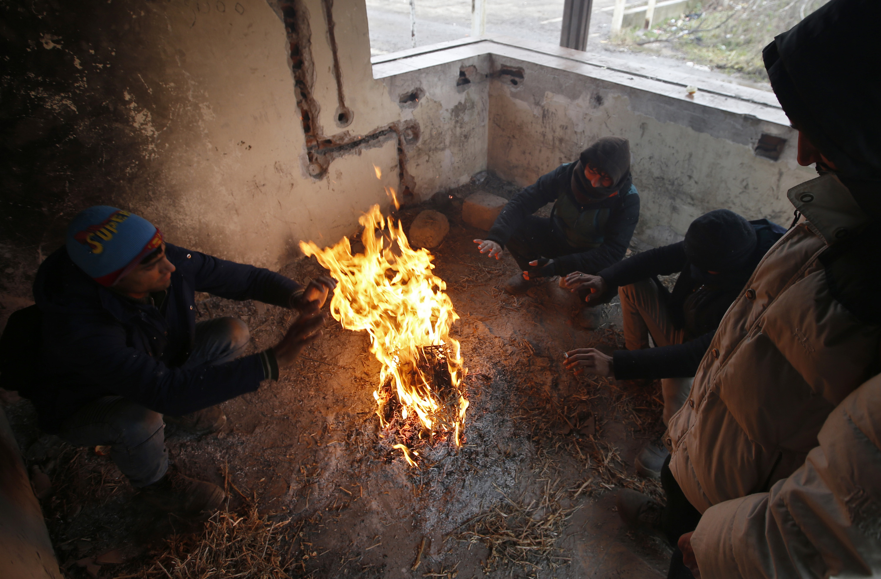 Групи мигранти си палят огньове, за да се защитят от минусовите температури