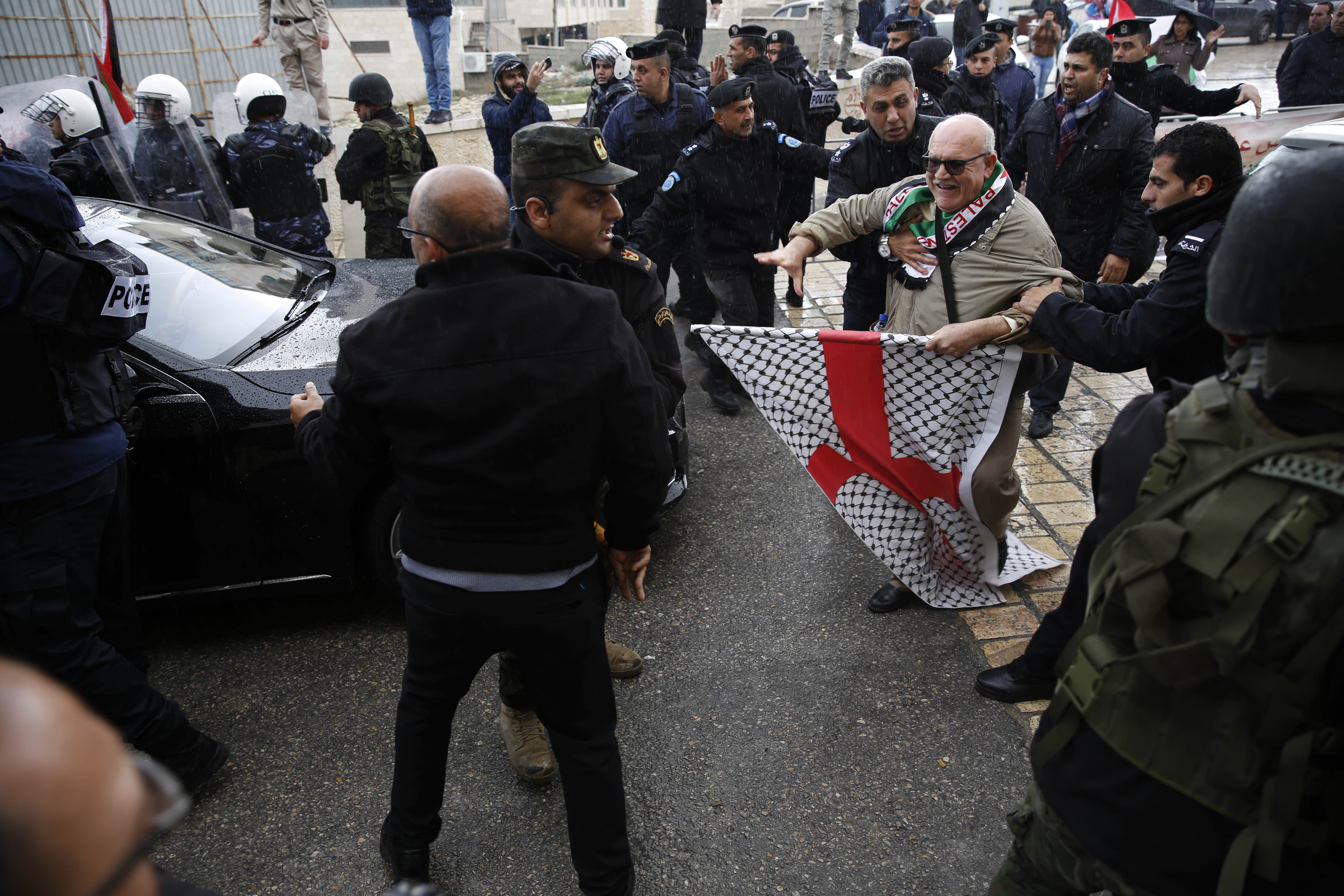 Палестински полицаи се опитват да попречат на демонстриращи палестинци, опитващи се да достигнат до колата на гръцкия патриарх