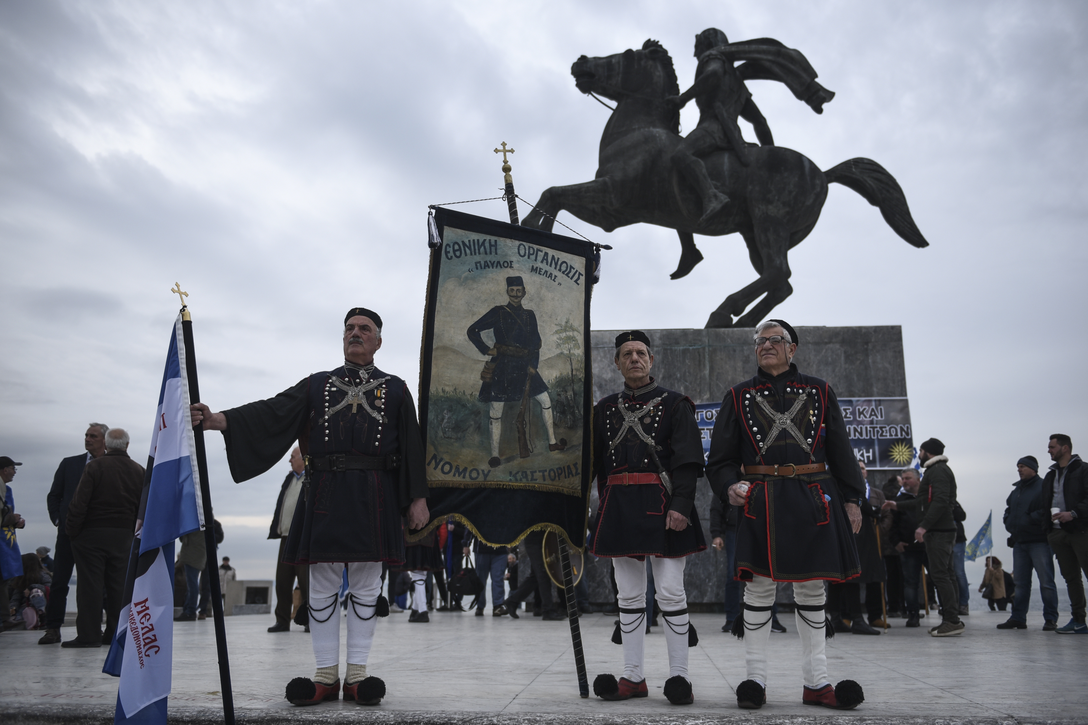 Гръцки протестиращи, облечени в традиционни костюми позират пред паметника на Александър Македонски в Солун