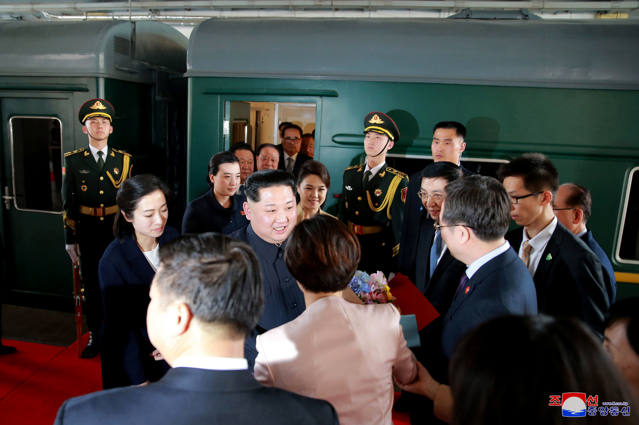 Ким Чен ур и съпругата му (вдясно от него) е посрещнат от членове на компарията на гара в Пекин
