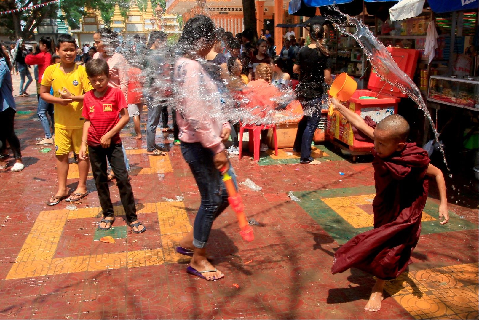 Пном пен, Камбоджа - дете будист залива със свещена вода минувачите в края на Кхмерската Нова година