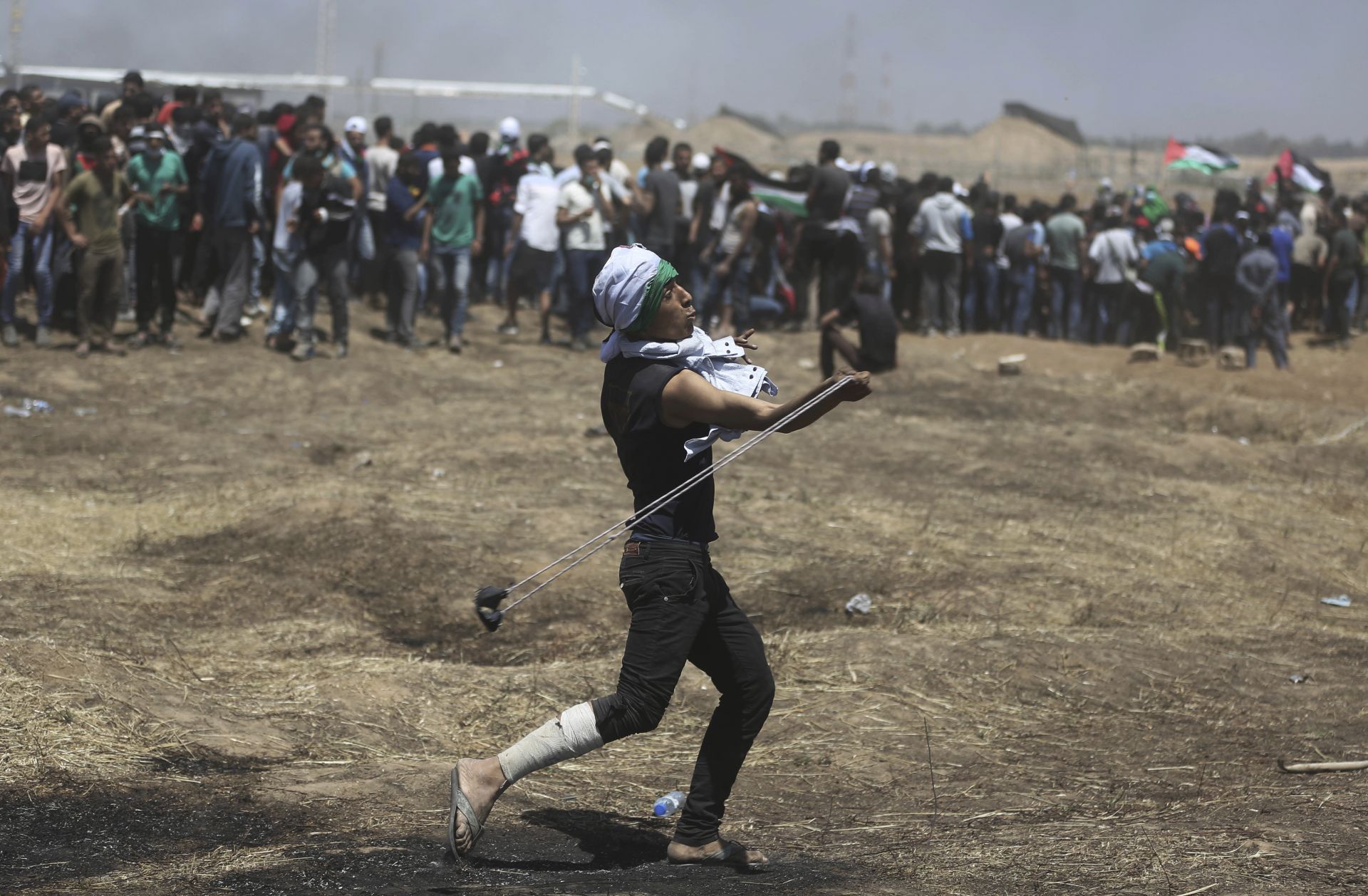 Палестинец хвърля камъни по израелските войнци по време на протеста край границата с Израел