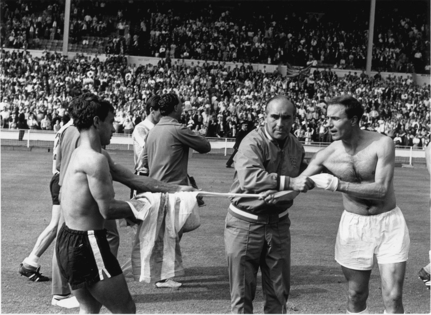 Сър Алф Рамзи спира Джордж Коен (вдясно) да си размени екипа с аржентински играч.