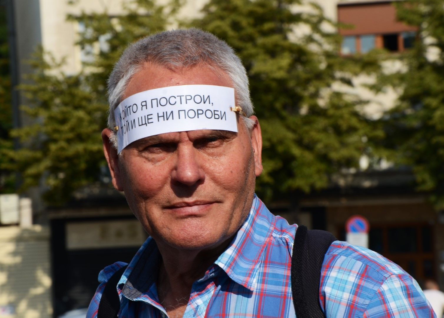 Протестиращ с плакат на челото 
