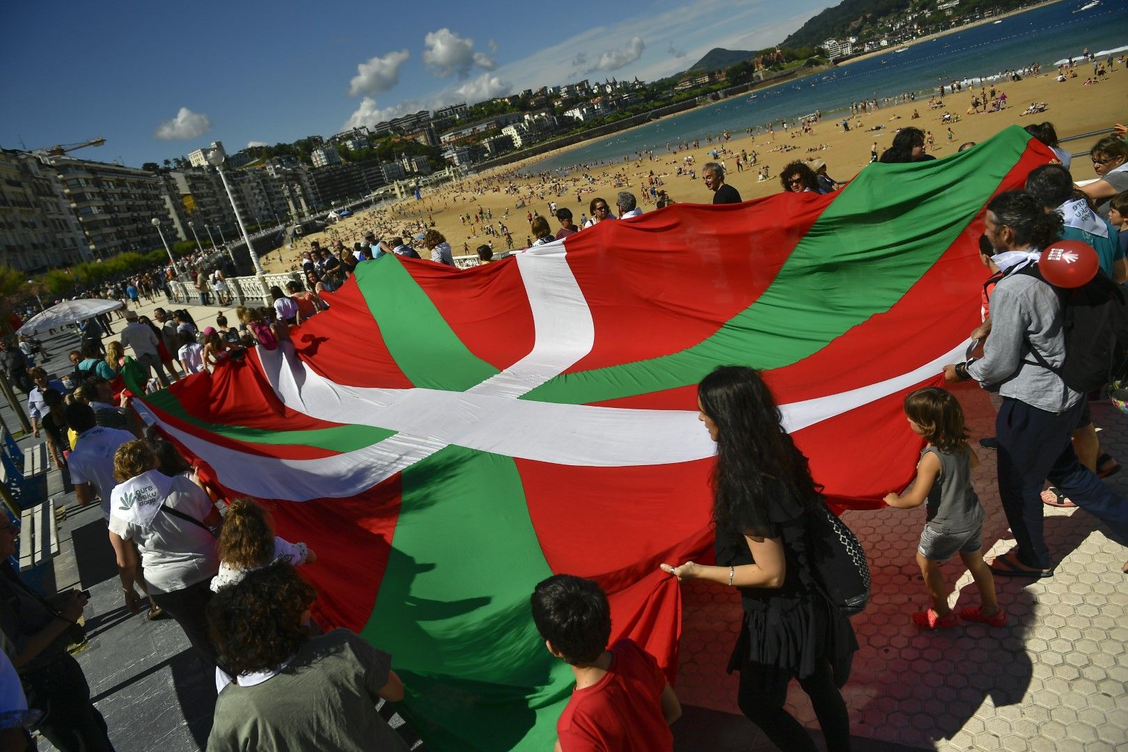 Демонстрантите държат флага на Страната на баските на плажа "Ла Конча" в Сан Себастиан