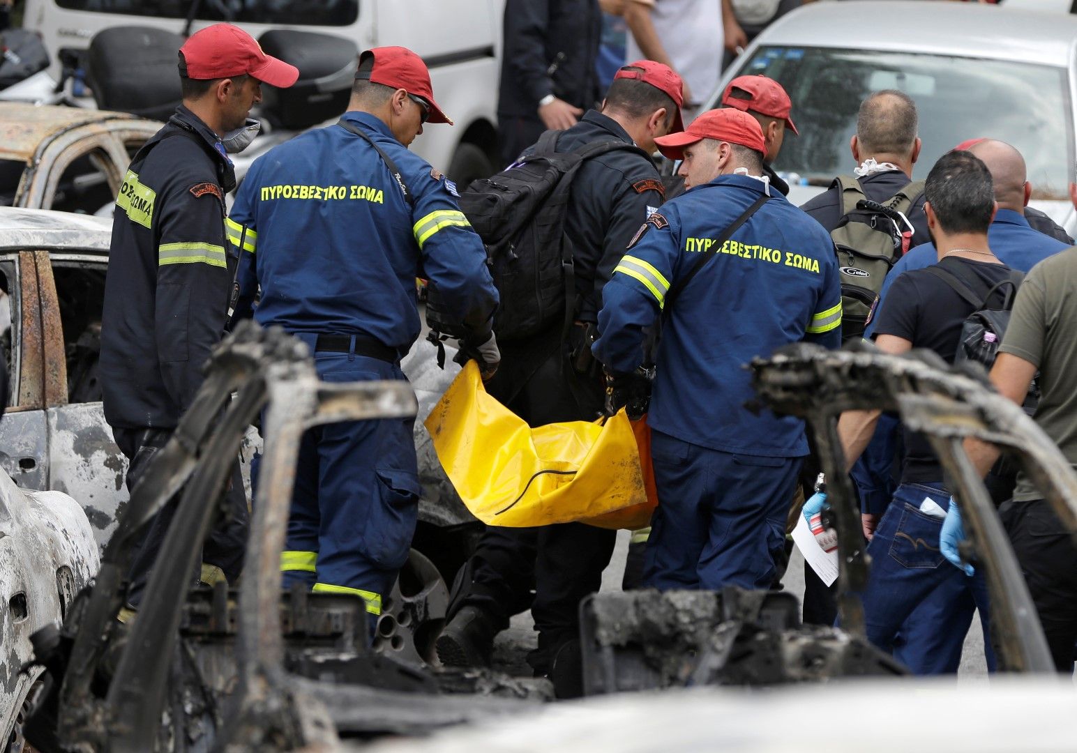 Спасителните екипи изнасят трупа на един на загиналите