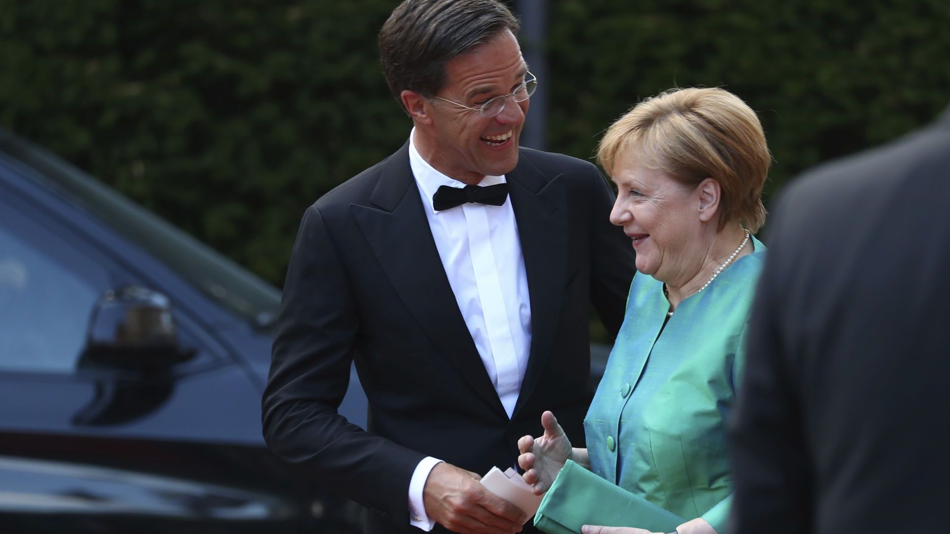 Меркел сияе в зелено на фестивал със съпруга си и Рюте