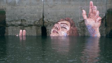 Жени, излизащи от водата, върху бетонните стени на крайбрежието на океана
