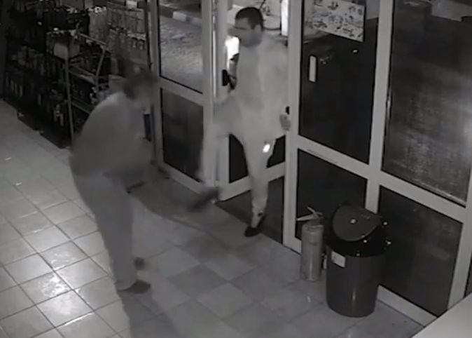 Биячът с белия костюм нахлува в магазина и започва да рита служителя