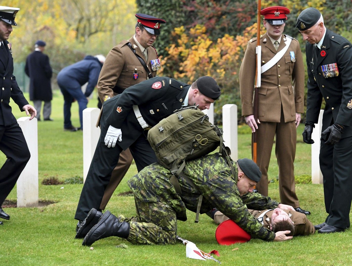 Канадски войник се е надвесил над британски, на когото му прилошало по време на възпоменателна церемония във военното гробище в Монс, Белгия, 10 ноември 2018ц