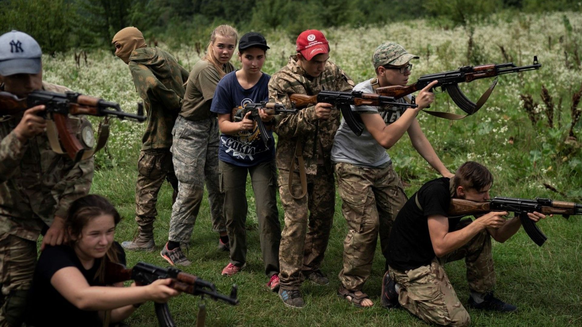 Лагерниците някои облечени в бойни униформи внимателно насочват пушките си