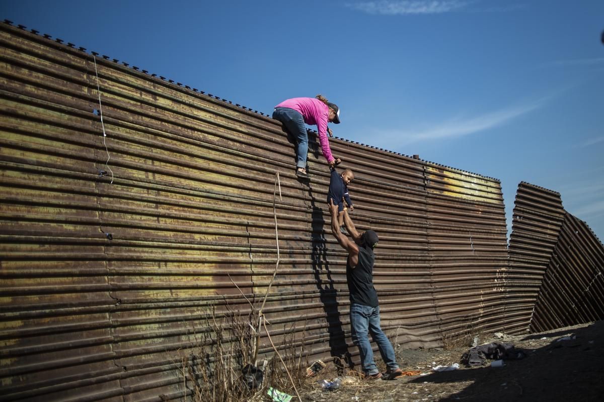 Мигранти от Хондурас преминават през оградата по границата между САЩ и Мексико при Сан Диего, Калифорния