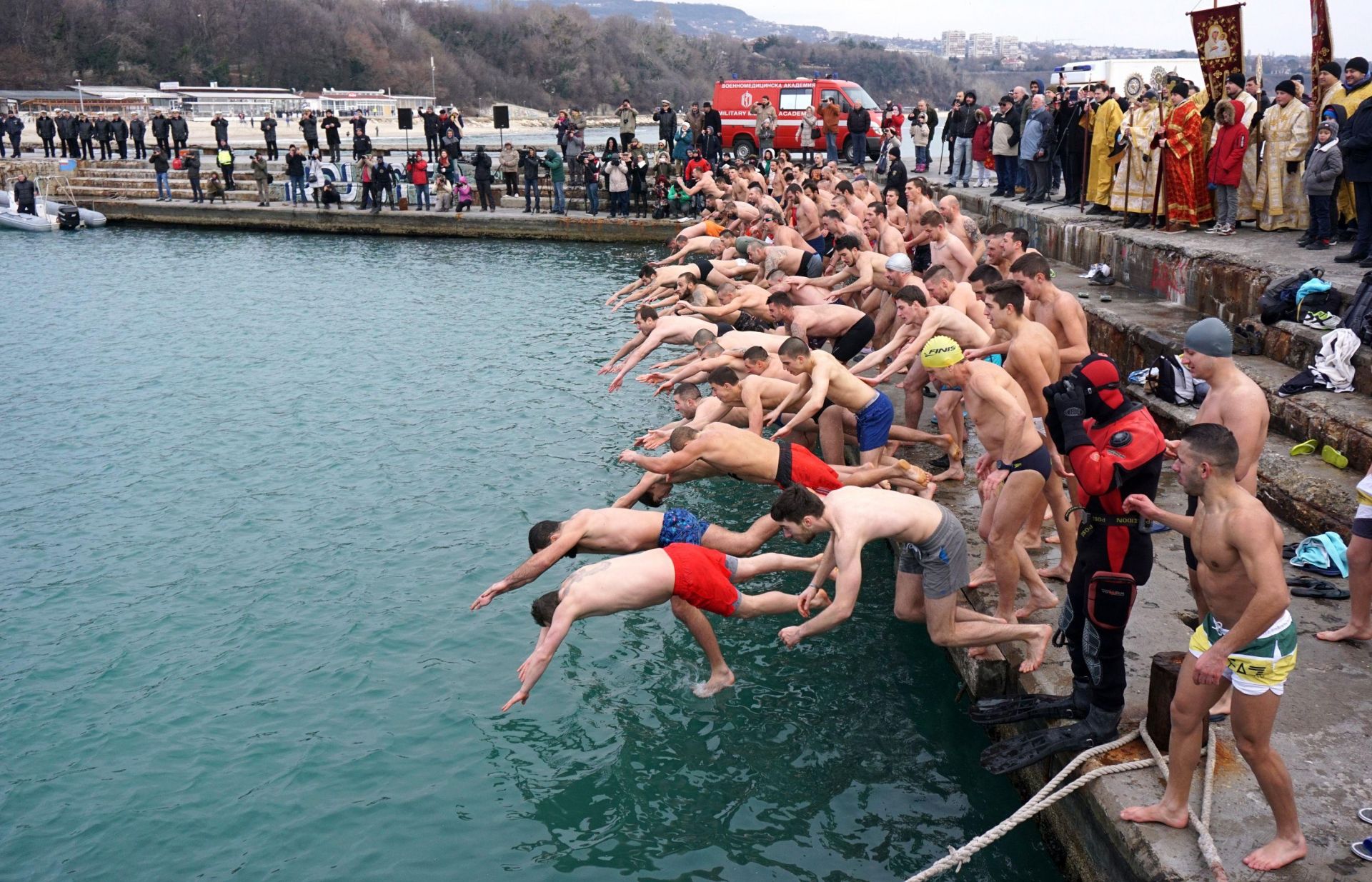 Въпреки обичайния за този сезон студ млади мъже скачат във водата и изваждат кръста от нея