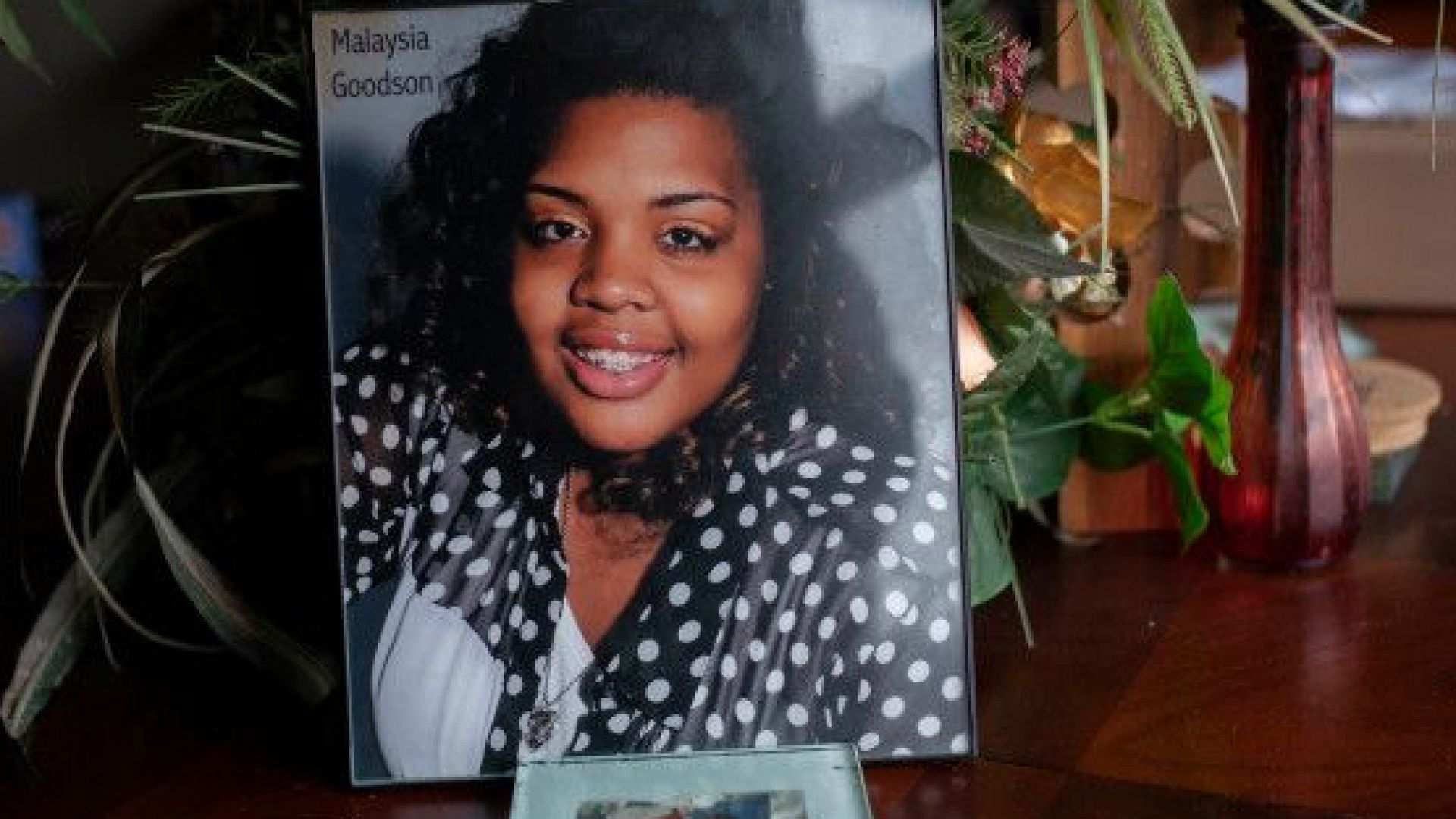 Млада майка носеща на ръце едногодишното си бебе детската количка