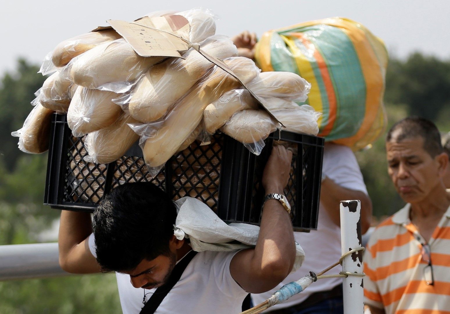Мъж носи щайга с хлябове, купени от най-близкия до границата колумбийски град