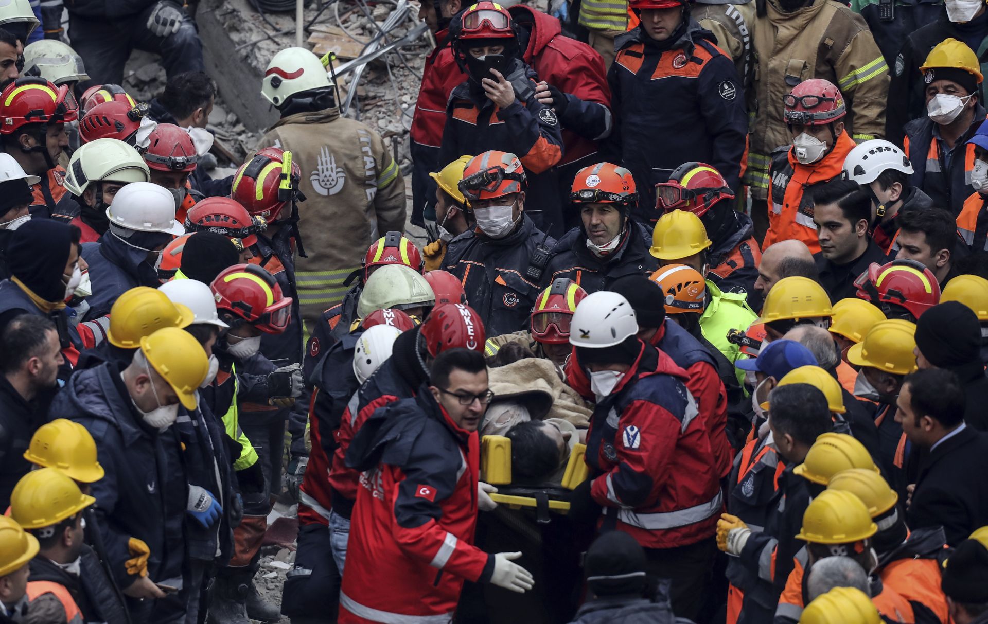 Спасители носят изваденото под руините на рухналия блок 16-годишно  момче
