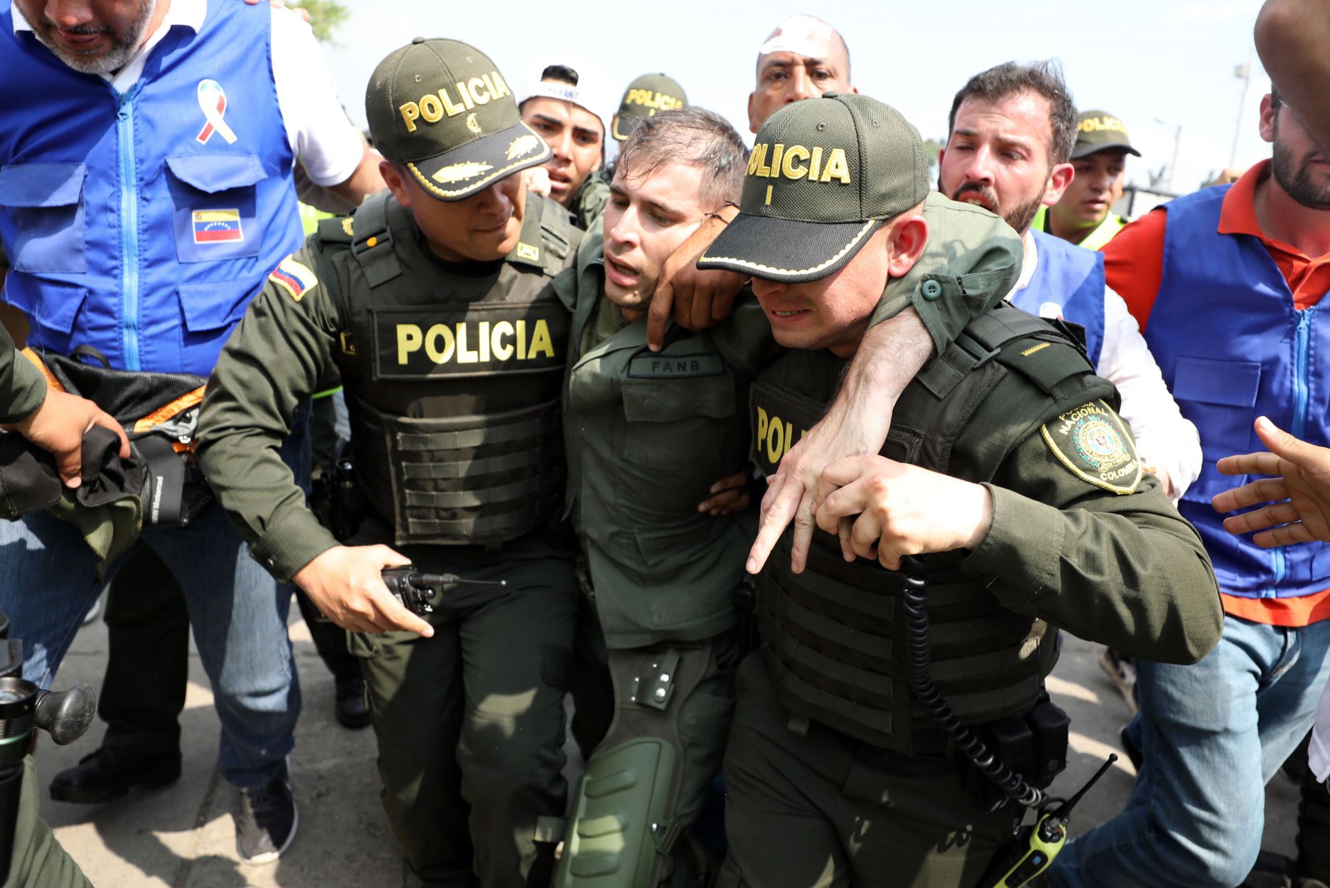 Колумбийски полиции ескортират венецуелски войник, който се предаде на международния мост Симон Боливар, където венецуелците се опитват да доставят хуманитарна помощ