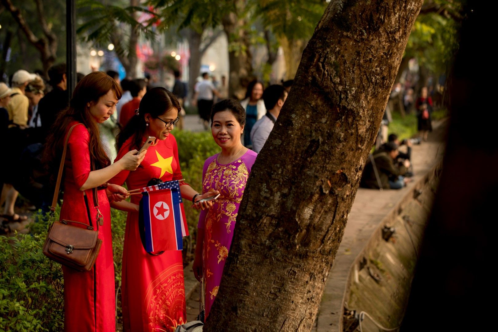 Виетнамски жени очакват Ким и Тръмп с националните флагове на Северна Корея и САЩ