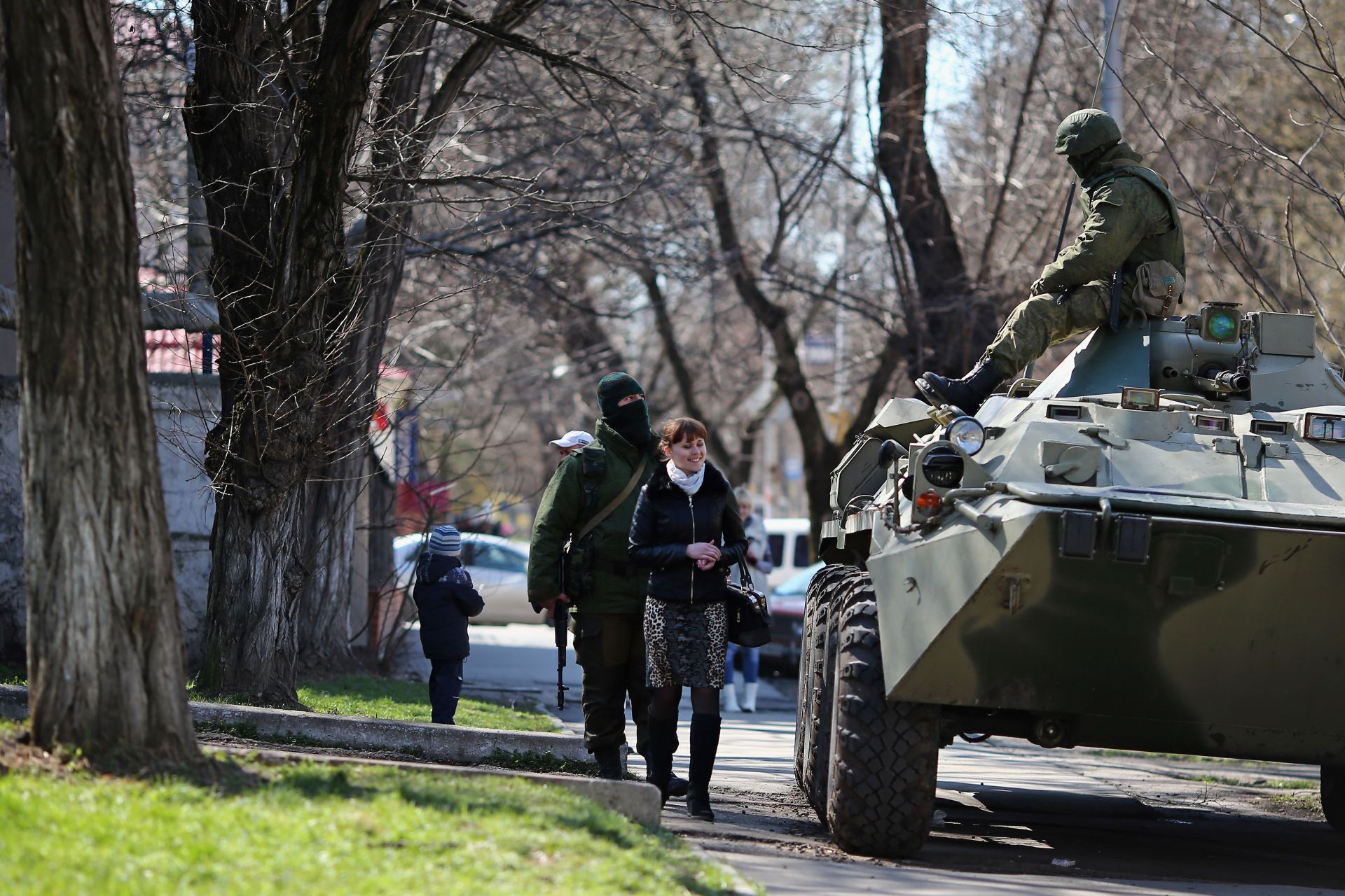 Жена минава покрай руски военнослужещ извън украинска военна база на 18 март 2014 г. в Симферопол