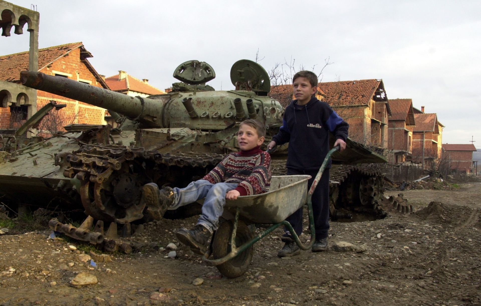 12 януари 2001 г. в Клина, Косово: Момчета играят с количка на едно от 112-те места, където НАТО използва бронебойни снаряди с обеднен уран по време на бомбардировките на Югославия през 1999 г.
