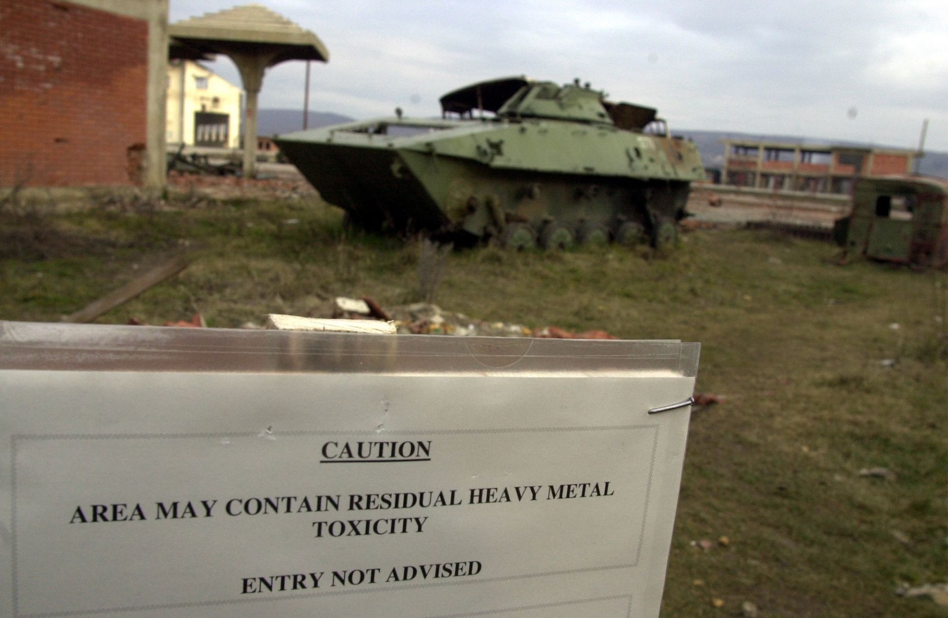 2001 г., в Клина, Косово: Табела предупреждава, че районът е едно от 112-те места, където НАТО използва бомби с обеднен уран по време на бомбардировките на Югославия през 1999 г. 2001 г., в Клина, Косово: Табела предупреждава, че районът е едно от 112-те места, където НАТО използва бомби с обеднен уран по време на бомбардировките на Югославия през 1999 г.