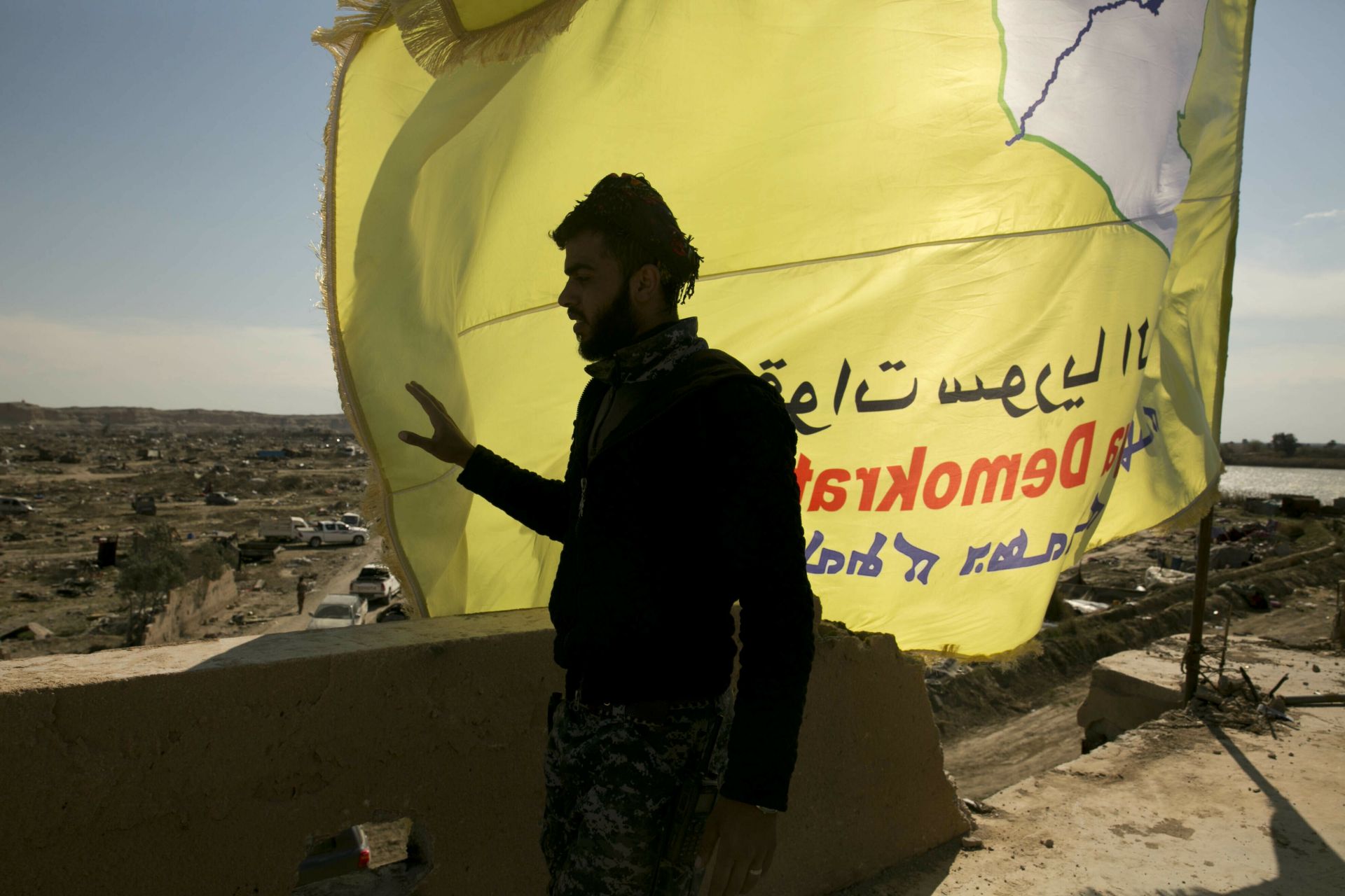 Подкрепеният от САЩ борец на сирийските демократични сили (СДФ) стои на покрив над Багуз