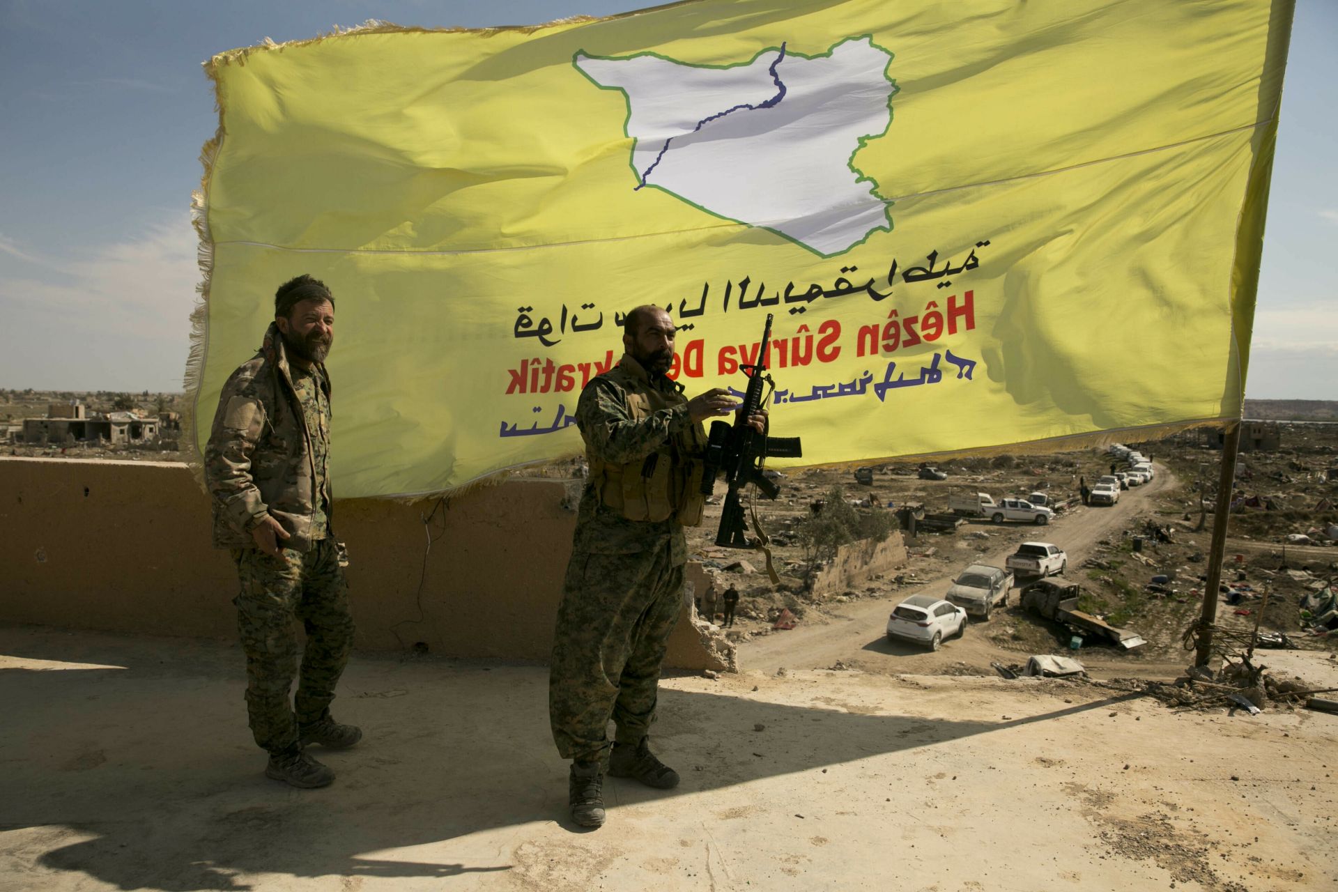 Подкрепени от САЩ бойци на сирийските демократични сили (СДФ) стои на покрив над Багуз