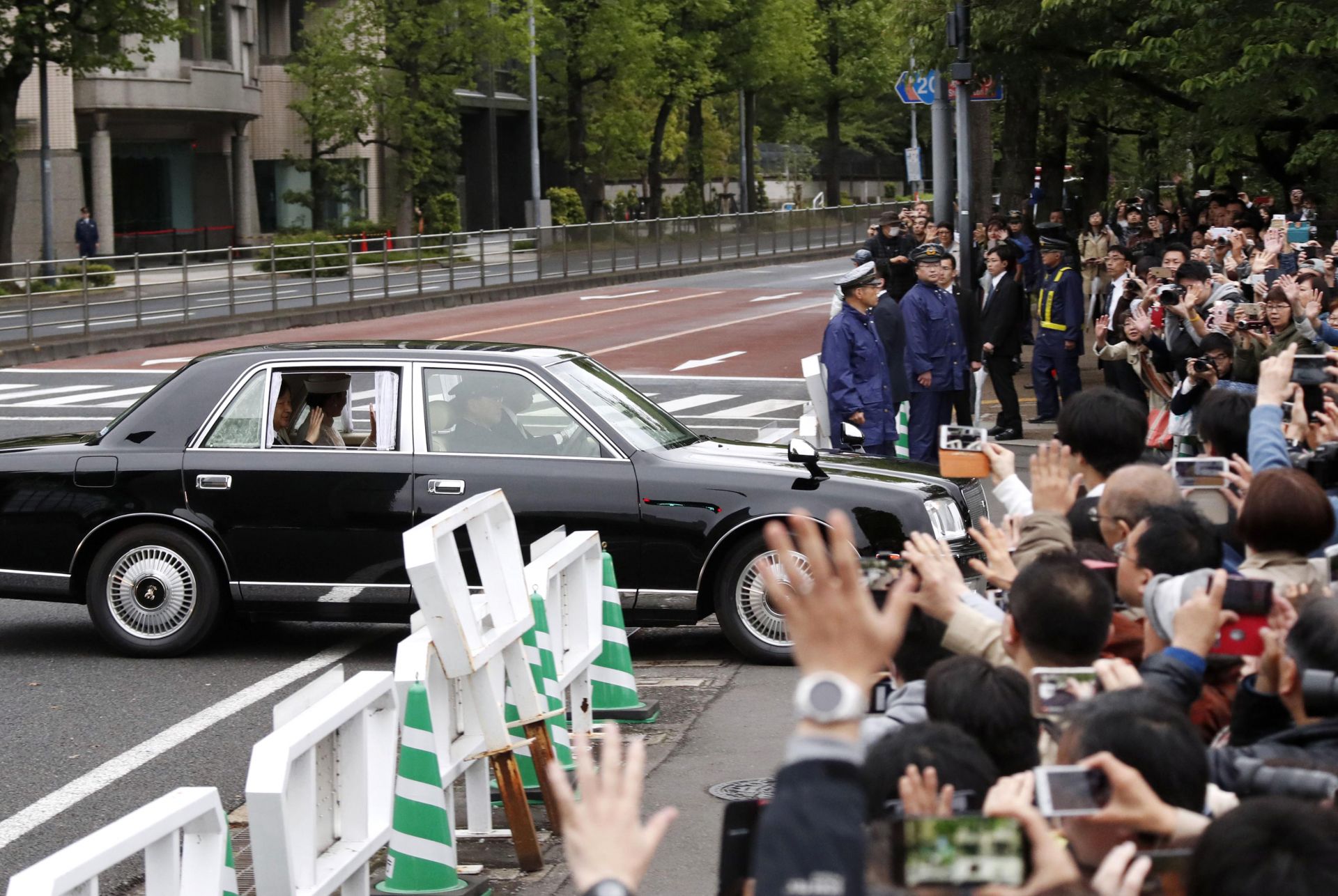 Японски приветстват японския принц Нарухито и принцеса Масако по пътя им към императорския дворец