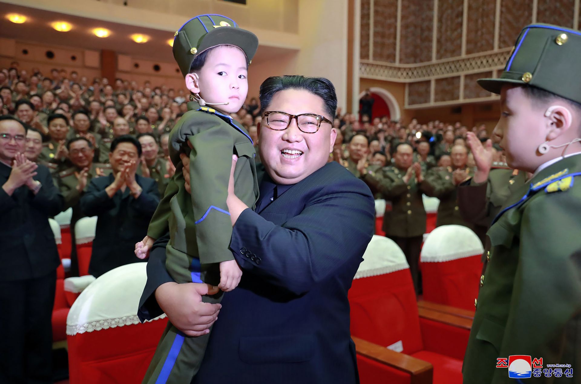 2 юни - Ким Чен-ун държи момче по време на музикално изпълнение на съпругите на офицерите на Корейската народна армия 