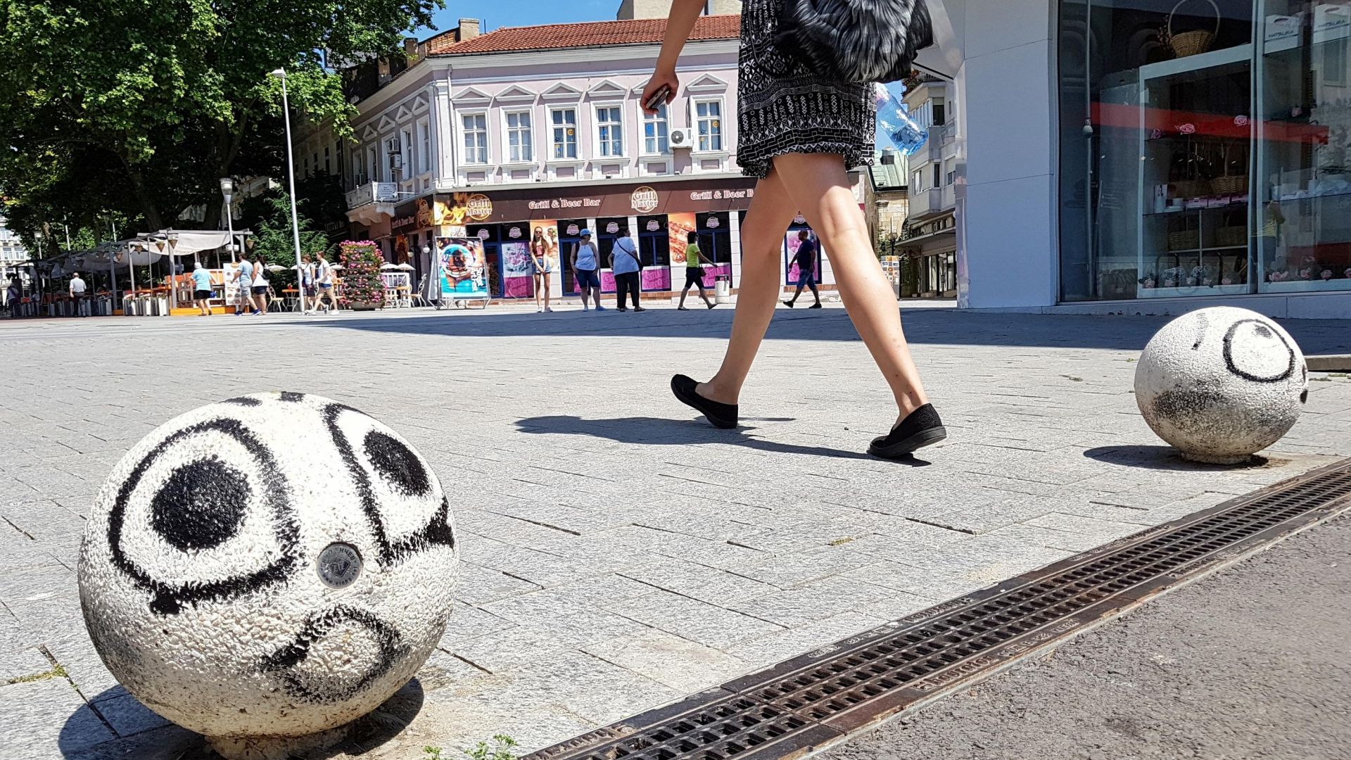 Неизвестен художник нарисува лица на уличните ограничители в началото на