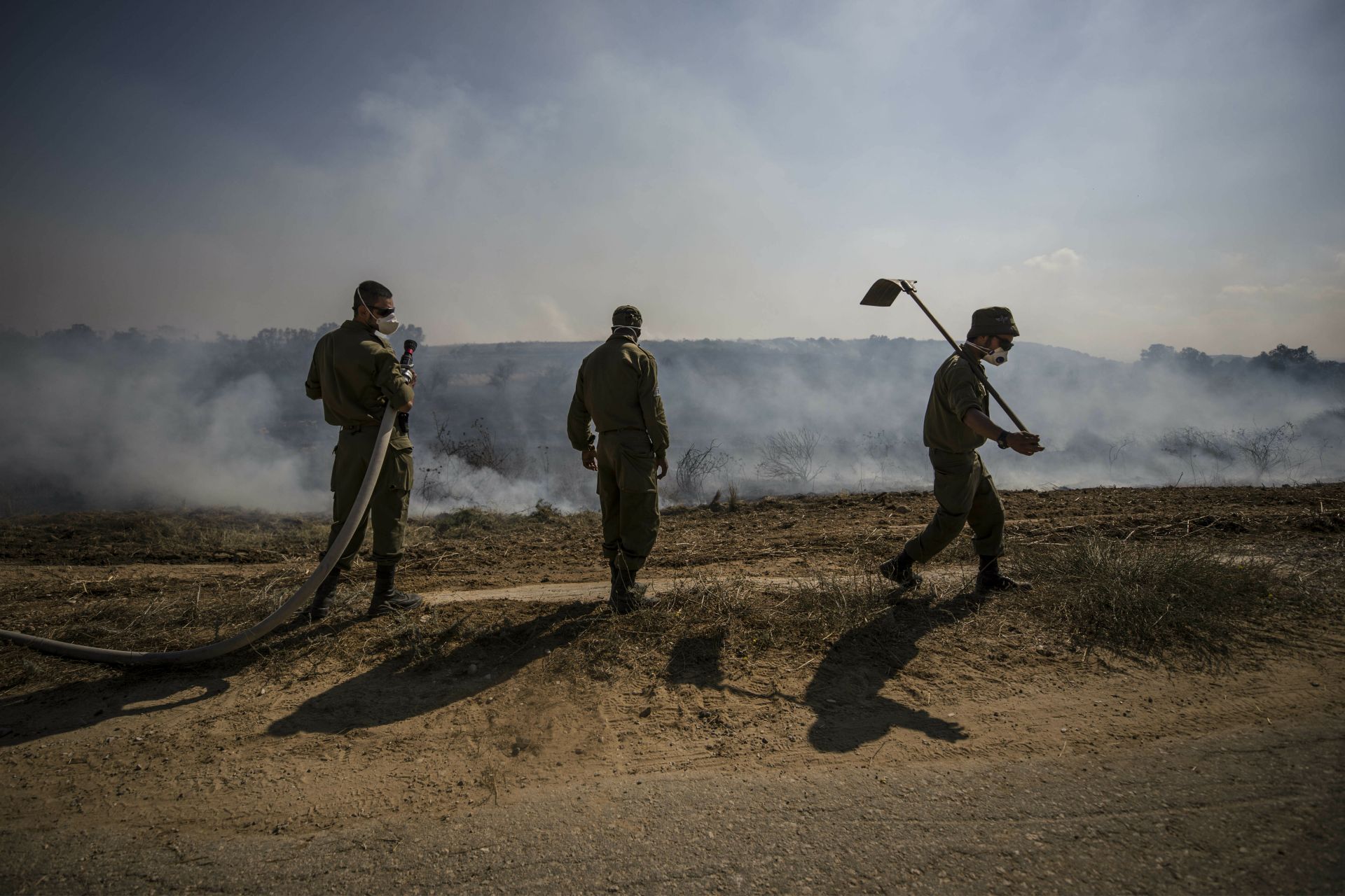 Израелски войници гасят пожарите, предизвикани от изстреляните от Газа запалителни устройства