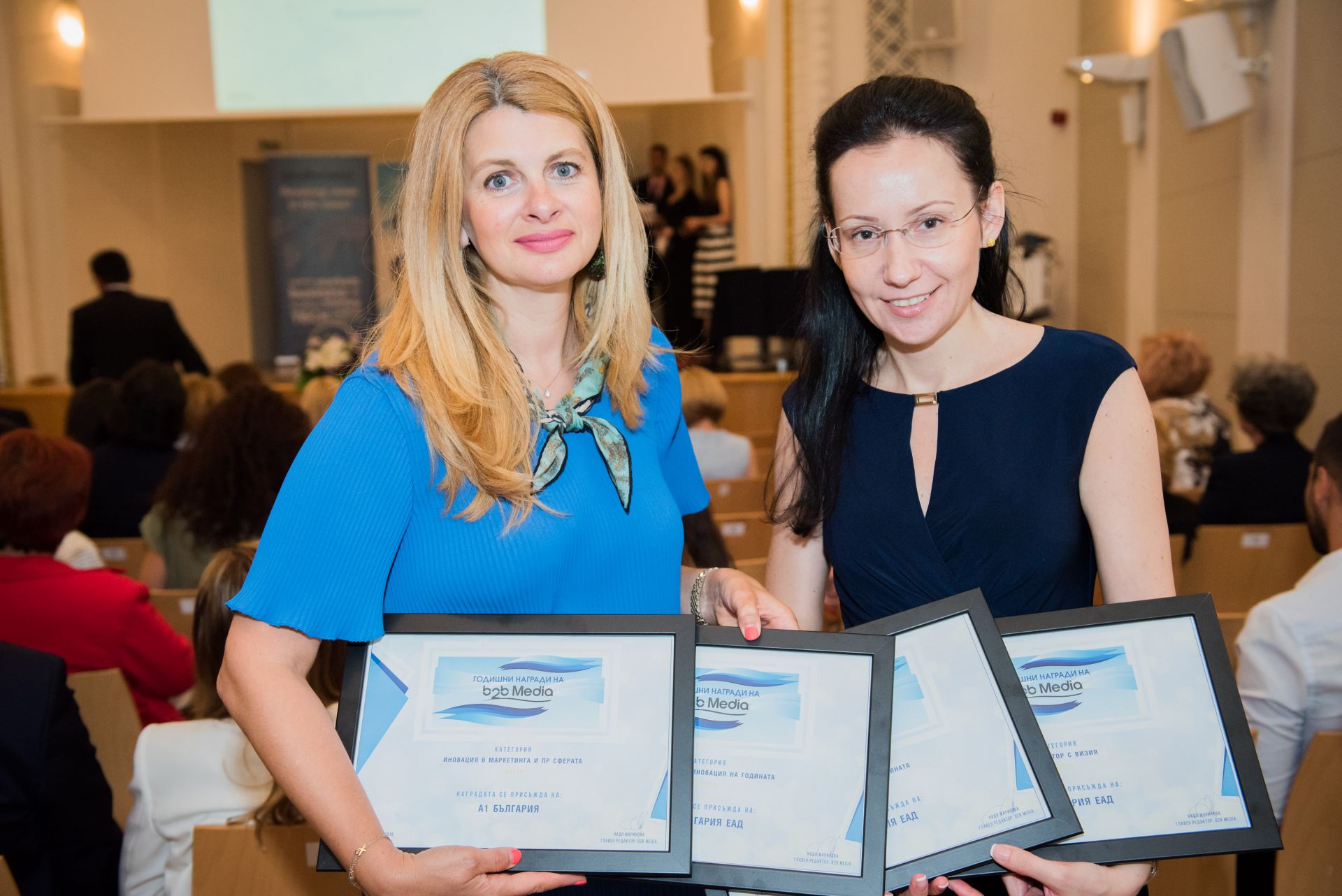 Илияна Захариева, директор „Корпоративни комуникации” и Биляна Дражева, мениджър „Вътрешни комуникации” в А1, с наградите, които компания получи на b2b Media Awards.
