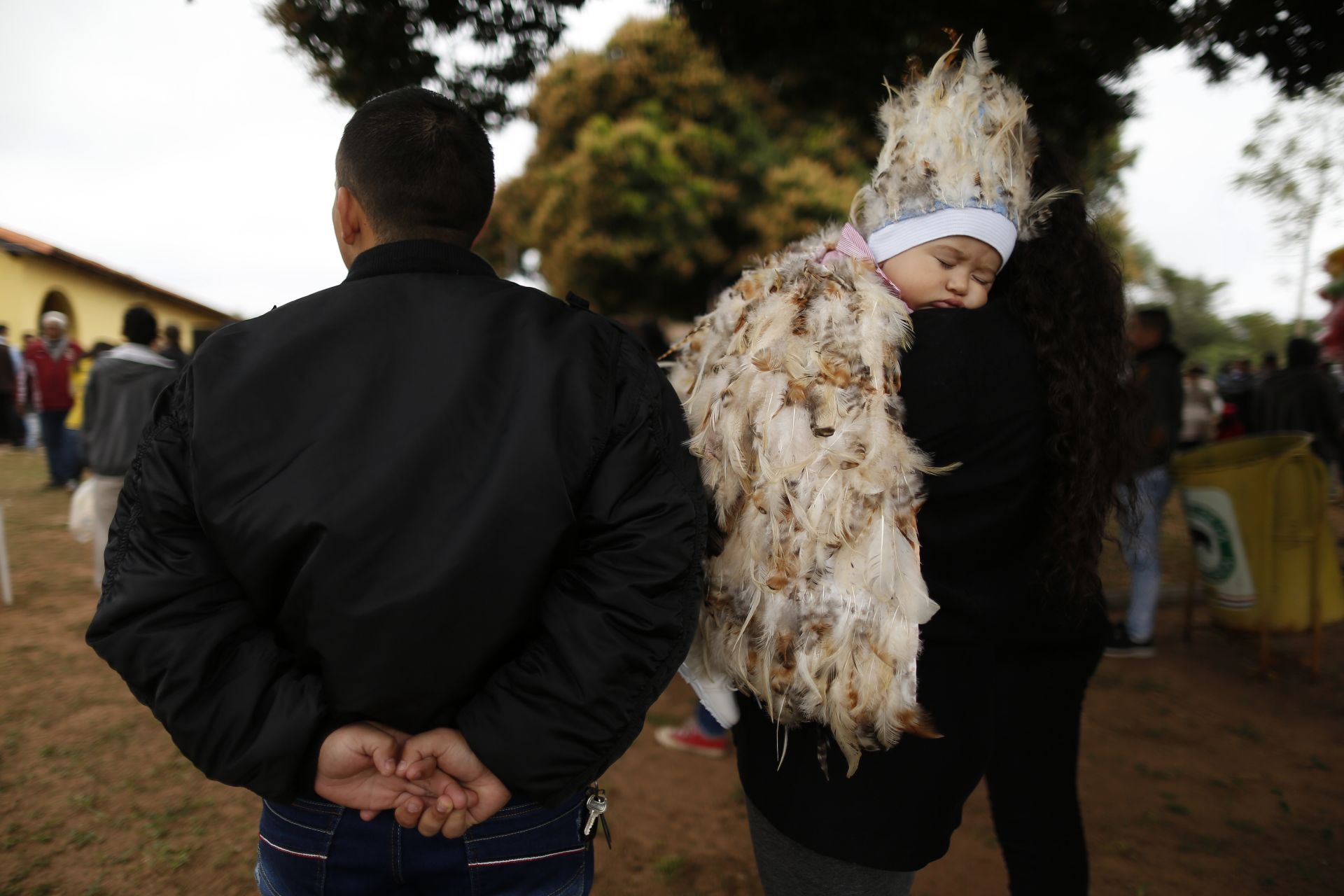 9-месечният  Хесус Кардозо сервин спи на рамото на майка си по време на службата 