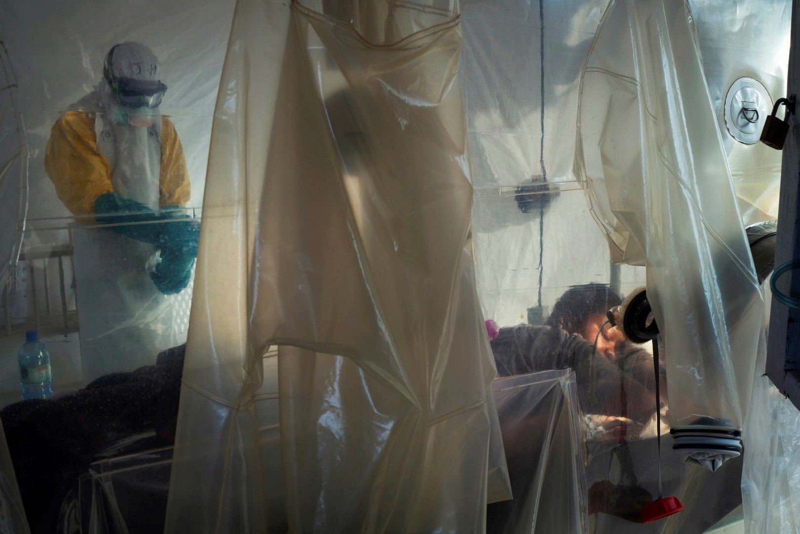 Здравни работници със защитна екипировка, проверяват изолиран пациент в център за лечение на Ебола в Бени, Конго