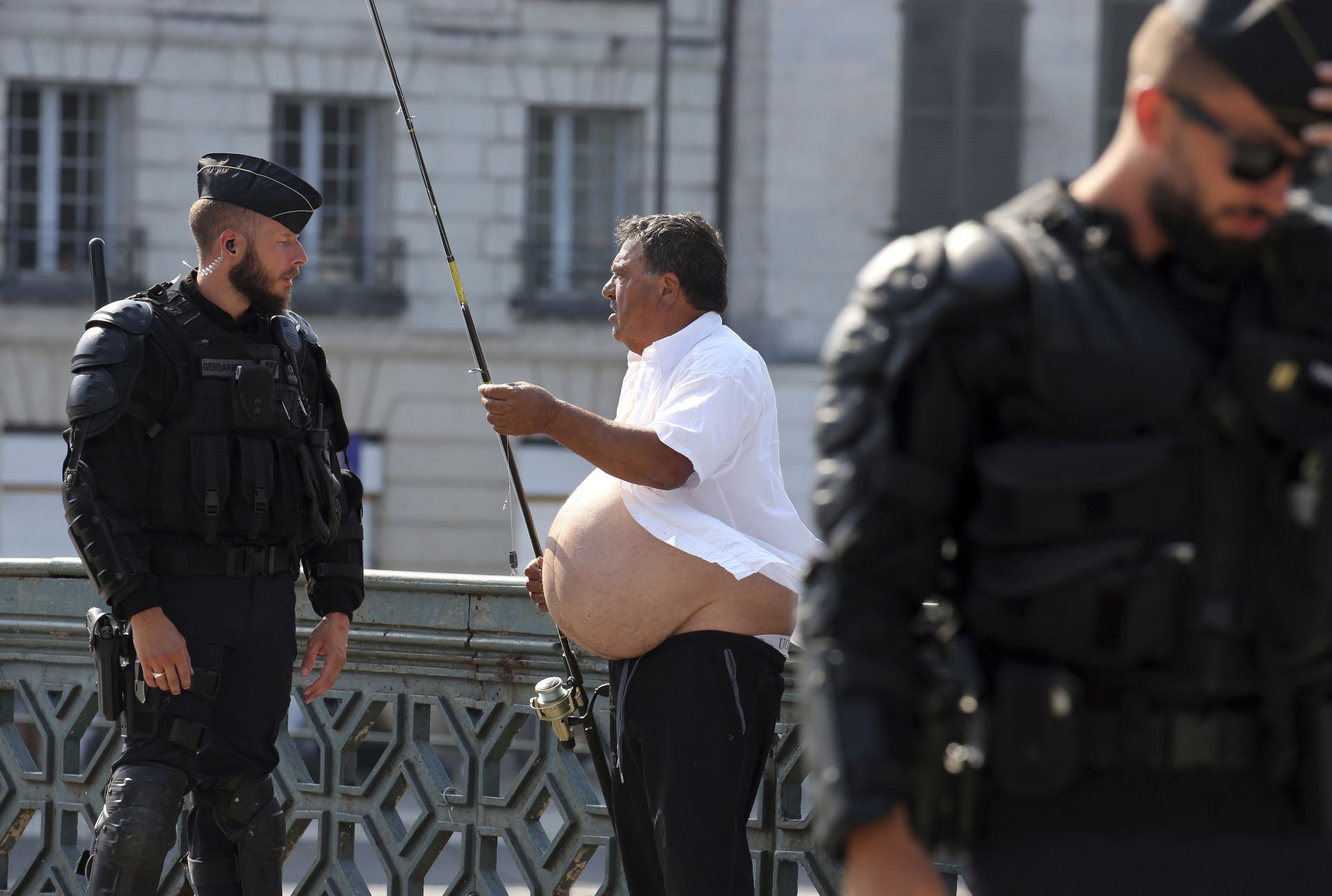 Френски полицай се опитва да изгони местен жител, който в знак на протест е отишъл да лови риба по време на срещата на върха