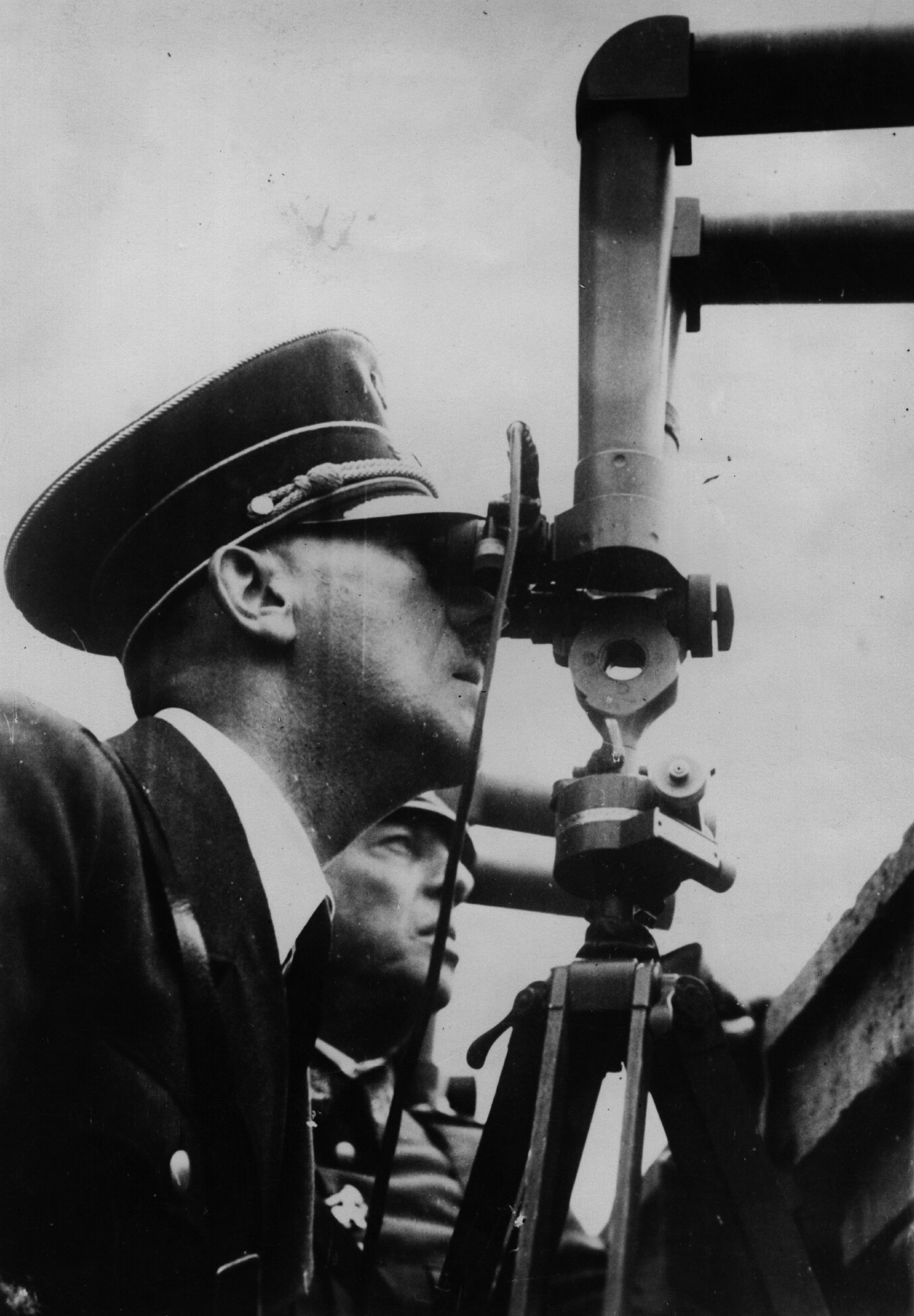  6 октомври 1939 година: С двете очи, залепени с перископ, немският деспот Адолф Хитлер (1889 - 1945) злорадства над руините на Варшава 