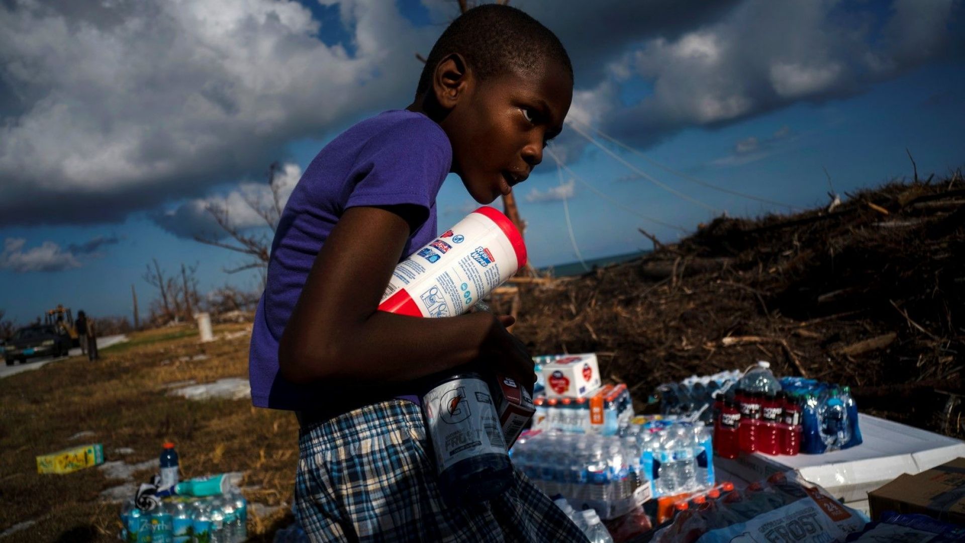 Айфон Минус, 8-годишен, събира дарена храна, която е била донесена с хеликоптер. 