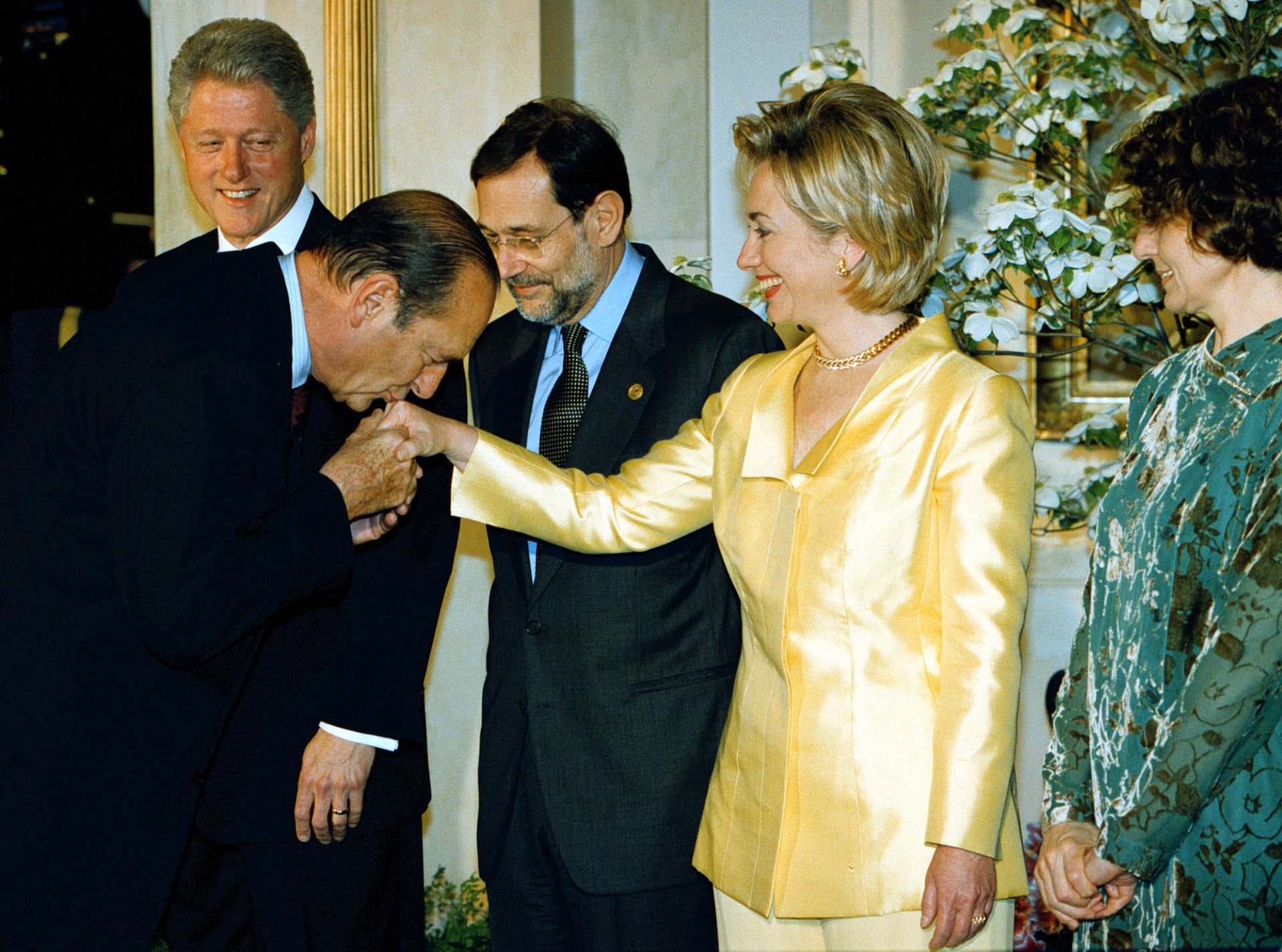 Жак Ширак целува ръката на Хилари Клинтън по време на среща на НАТО през 1999 г.