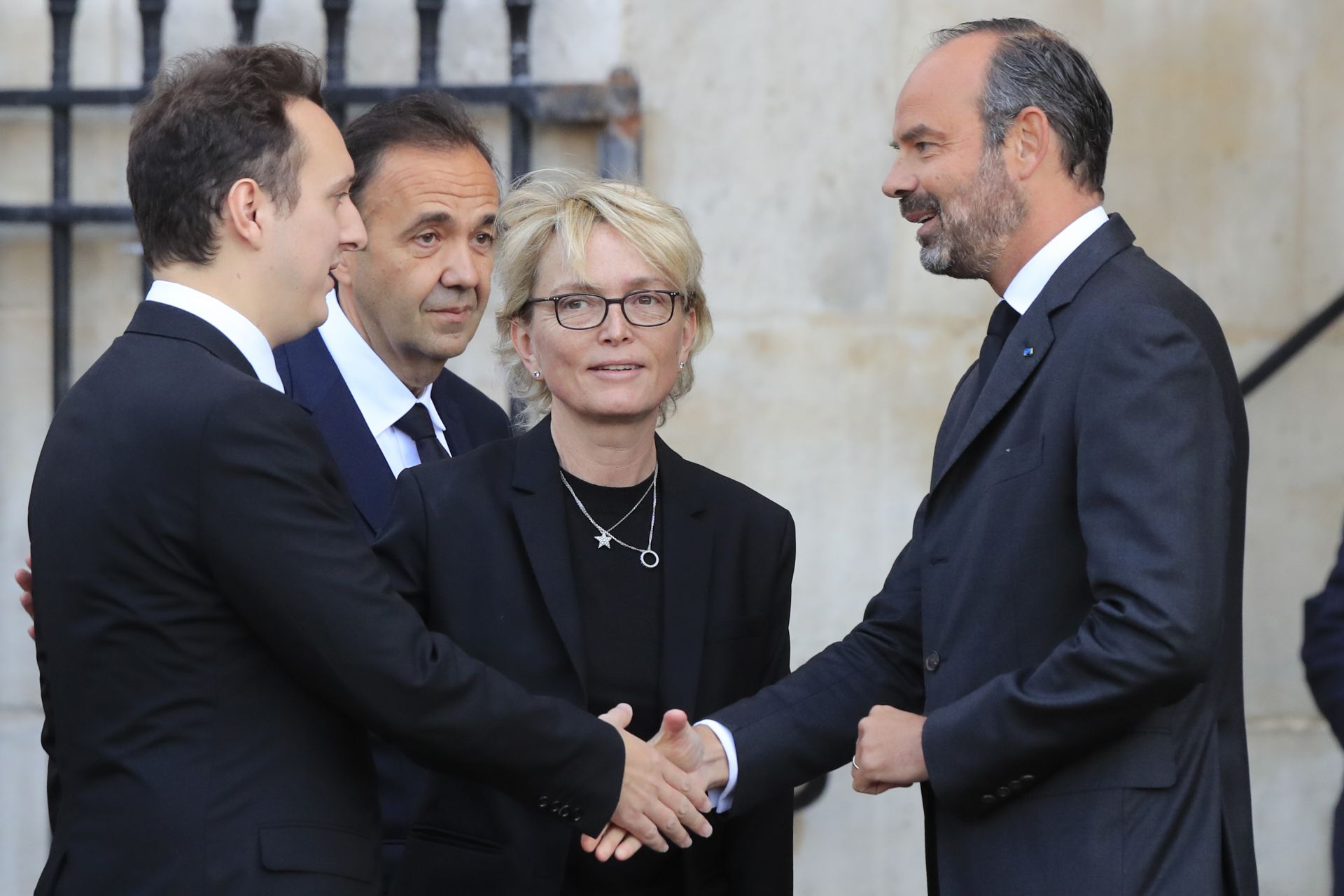Френският министър-председател Едуар Филип, вдясно, поздравява Мартин Рей-Ширак ( вляво) и Клод Ширак -  син и дъщеря на бившия президент Жак Ширак пред църквата 