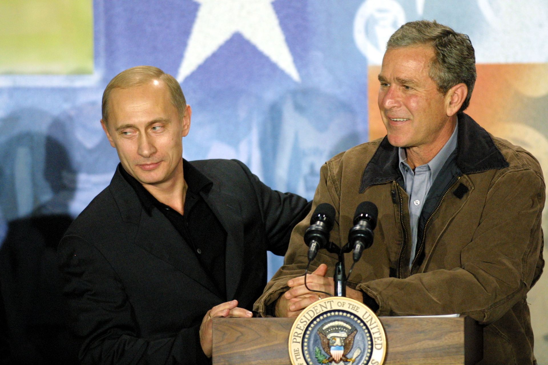 15 ноември 2001 г. - Владимир Путин и президентът на САЩ Джордж Уокър Буш говорят по време на посещение в Крауфордската гимназия в Крофорд, Тексас. Буш и Путин приключиха тридневна среща на върха, без да постигнат съгласие за система за противоракетна отбрана на САЩ, но се съгласиха да намалят ядрените запаси на техните държави.