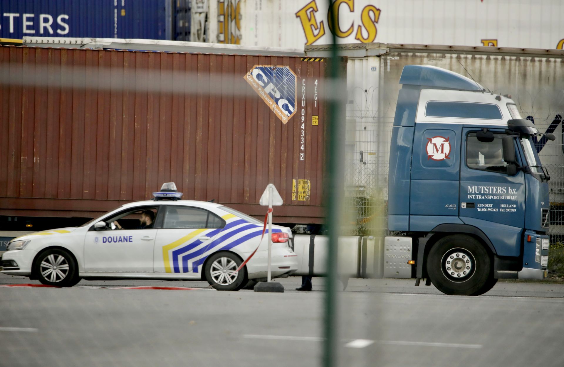 Полиция до камион, който чака да премине през сканиращ тунел на пристанище Зеебрюге