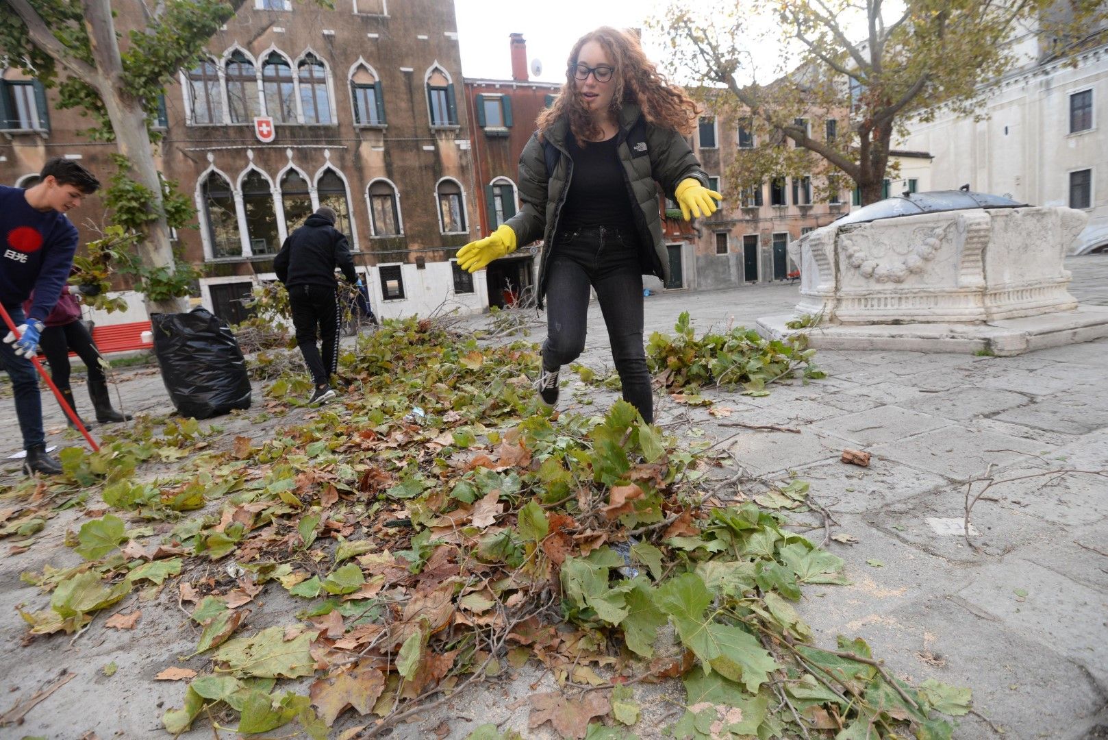 Жена почиства след отеглилата се висока вода във Венеция