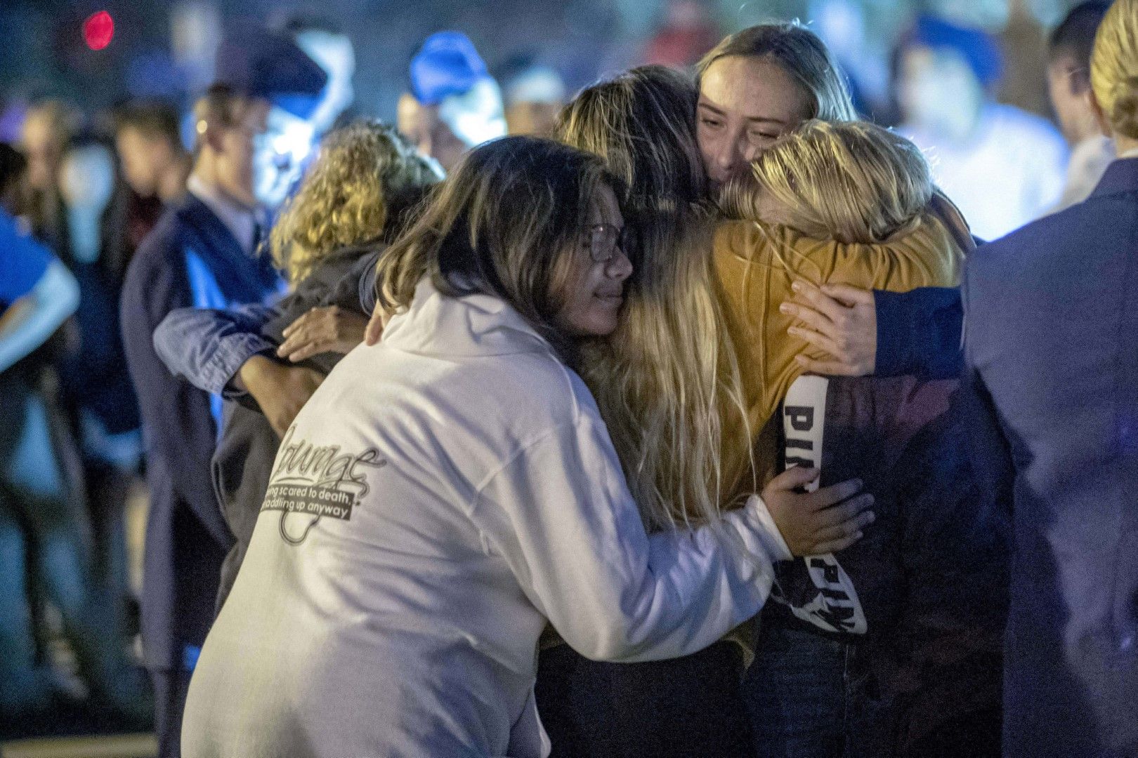 Хора се прегръщат по време на бдението в памет на двете жертви на стрелбата в гимназия Согъс в Санта Кларита