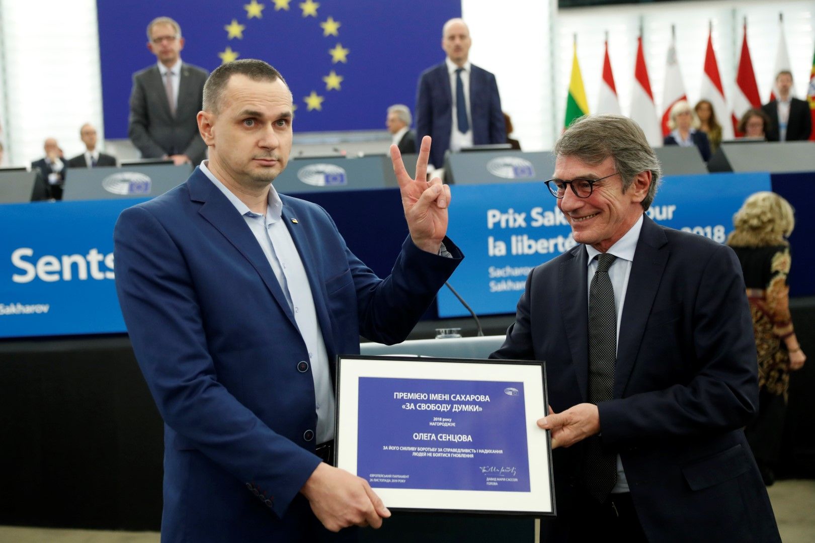 Олег Сенцов получава наградата от Давид Сасоли и изобразява с ръка знака "Победа"