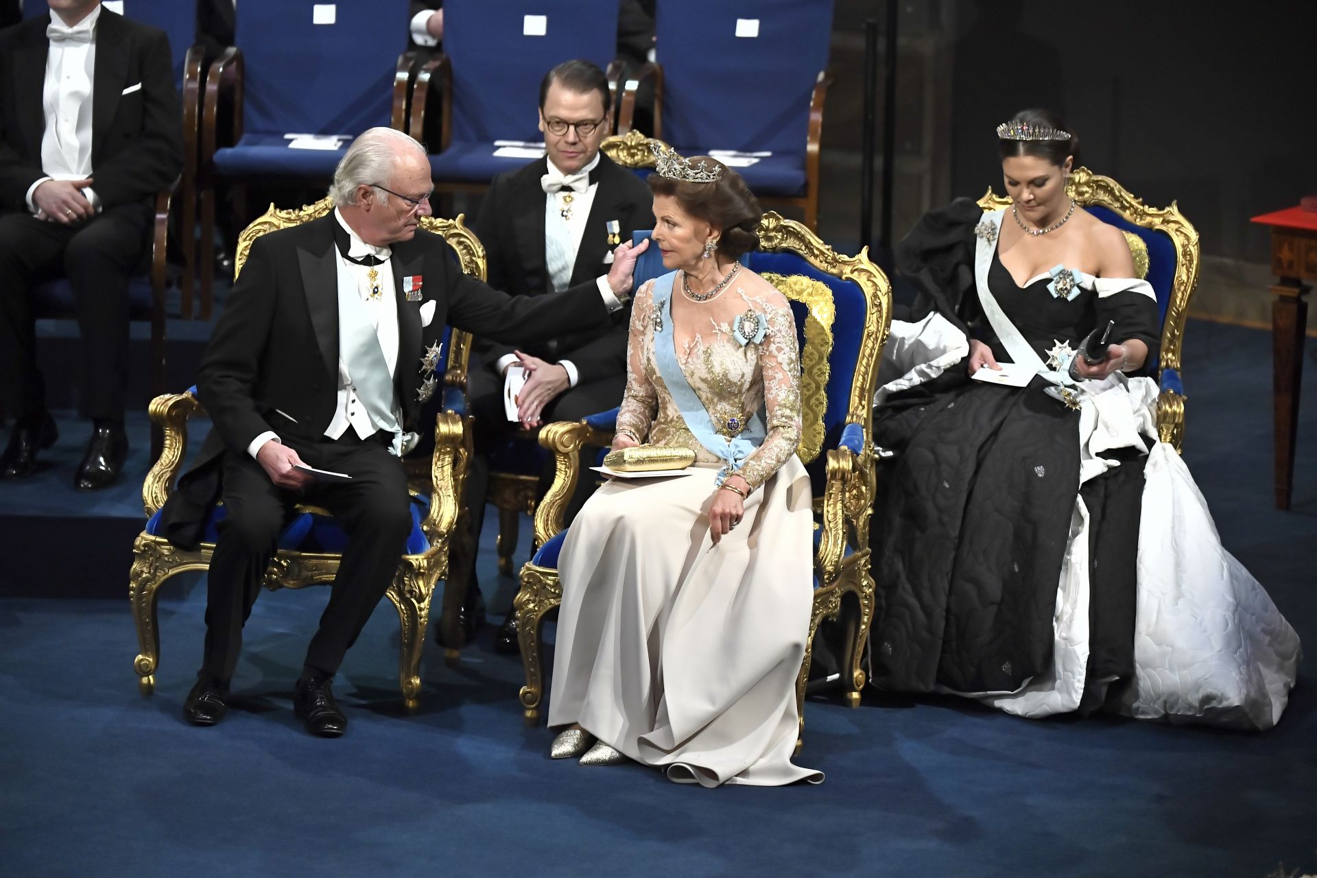 Кралят на Швеция Карл Густаф оправя възглавница на кралица Силвия на церемонията по награждаването на Нобел в Концертната зала в Стокхолм