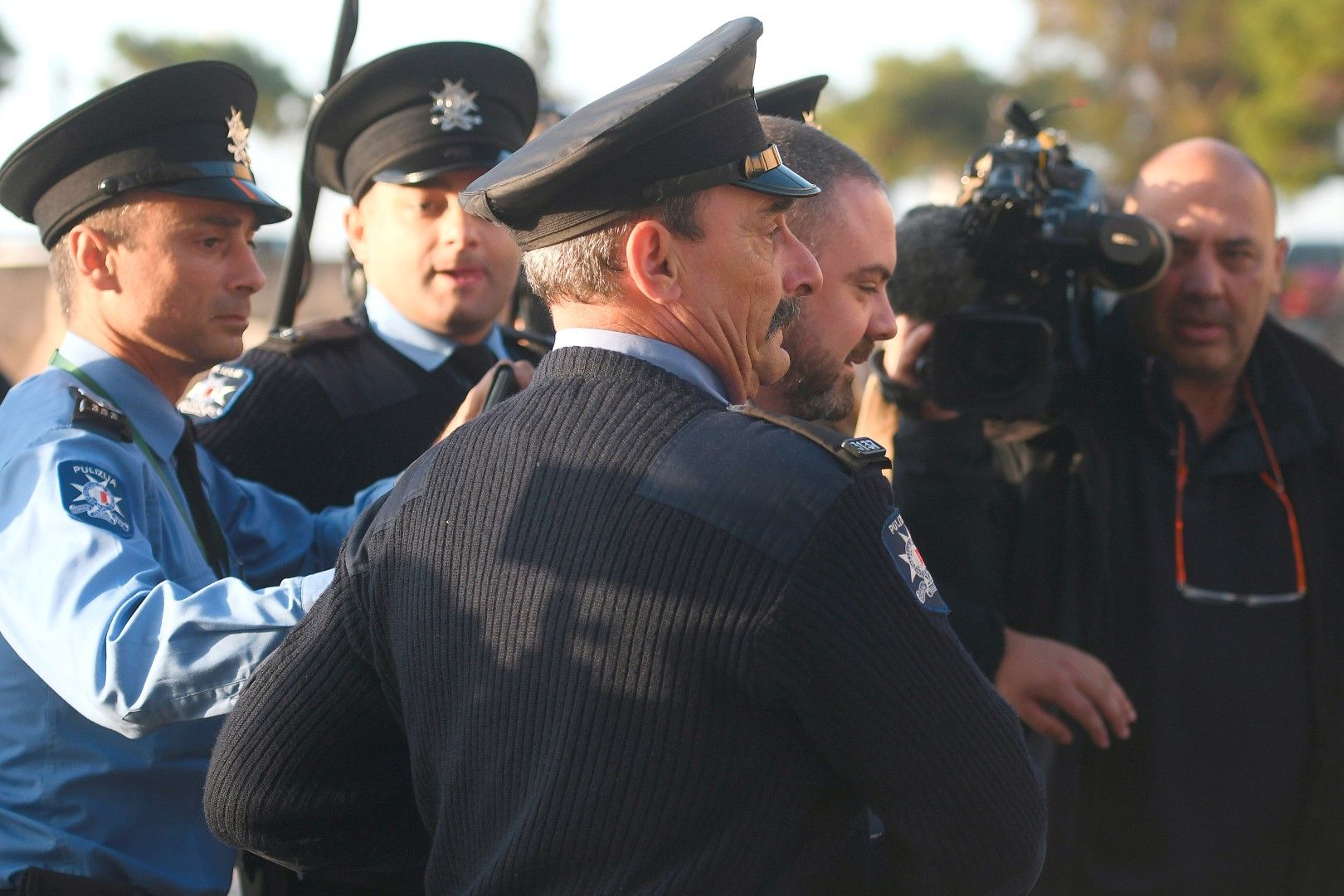 Министърът на правосъдието на Малта Оуен Боничи е ескортиран от полицията, която го предпазва от протестиращи, преди да влезе в офиса на премиера Джоузеф Мускат, 3 декември 2019 г.